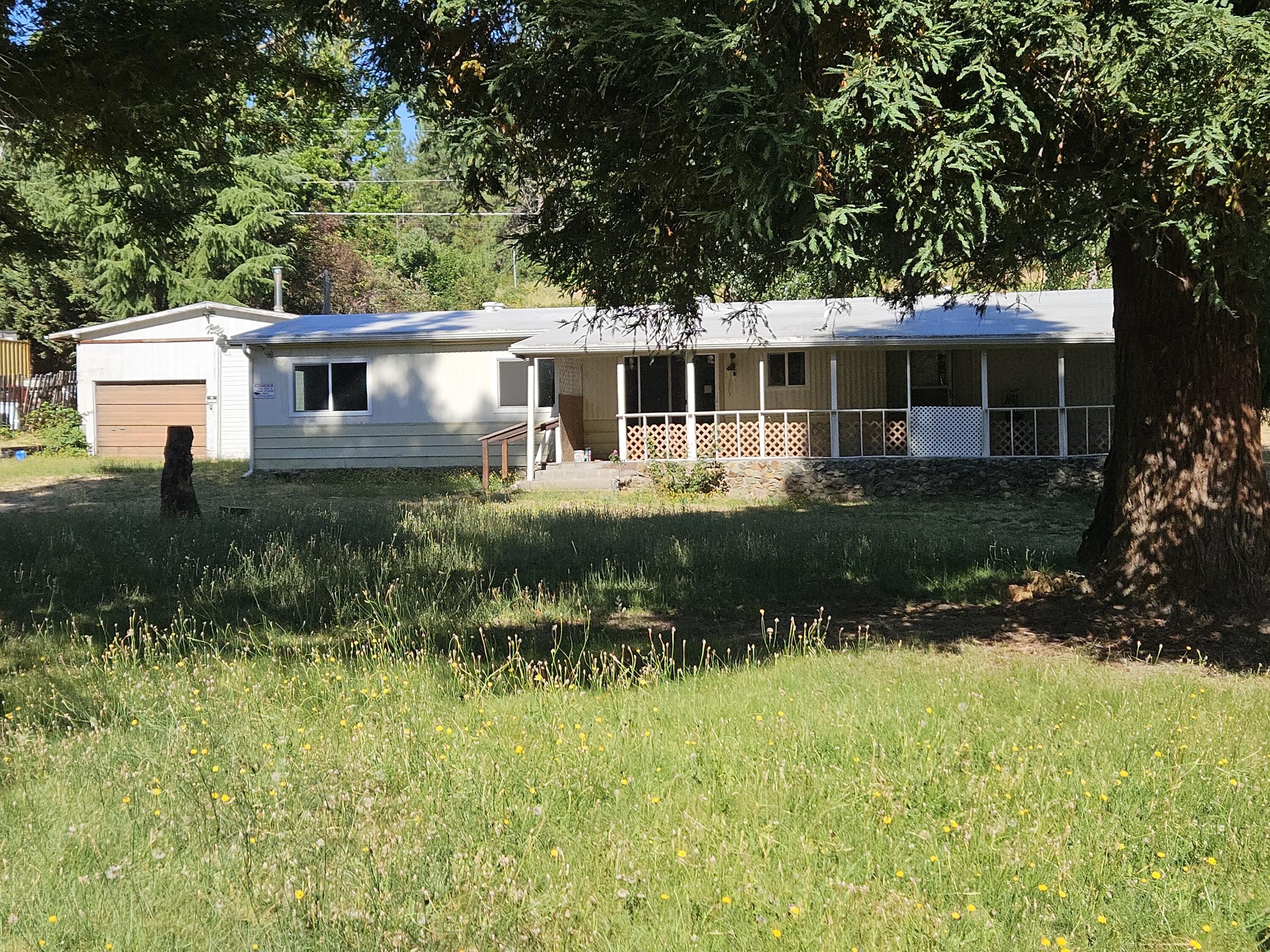 County has the mobile as a 2bd, 2 bath app 1414 sq ft, Has had some additions to it to increase size and space. Mobile is livable, Just needs some TLC. Flat lot is clean with a detached 2 car garage/shop (576 sq ft). Quiet little spot just minutes from shopping and medical. Great outdoor space with many options. Newer roof, vinyal winows, & ductless heat/ac. GPID water. Cash only sale.
