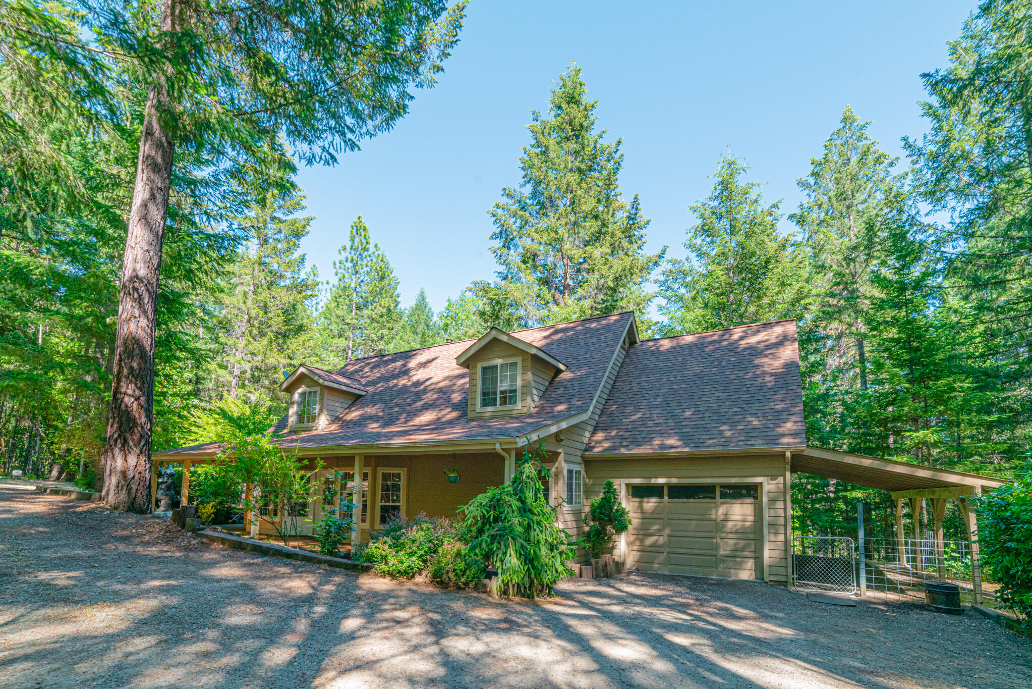Nestled in the woods & close to the Rogue River, lovely home on 2.56 acres with attached garage, plus separate shop! Built in 1996, in a beautiful neighborhood, the home features 3 beds, 2 ½ baths, 2049 sq ft open floor plan & hardwood floors.  Main level boasts woodstove with blower in the spacious living room, half bath, dining area with bay window, primary suite and kitchen with pull-outs & walk in pantry.  Upstairs you will find 2 large bedrooms both with dormer windows & vaulted ceilings, a full bath & walk in hall closet. Oversized single car garage with laundry, just off the kitchen. Relax out on the wrap around covered porch or on the new back deck overlooking the beautiful forest, unless you are pursuing your hobbies in the wonderful shop, complete with garage space for vehicles, built in shelves & work bench, plus a large bonus/rec room with office & walk in storage closet! Carport/dog kennel, beautiful grounds & circular drive. Is this slice of paradise YOUR new home?