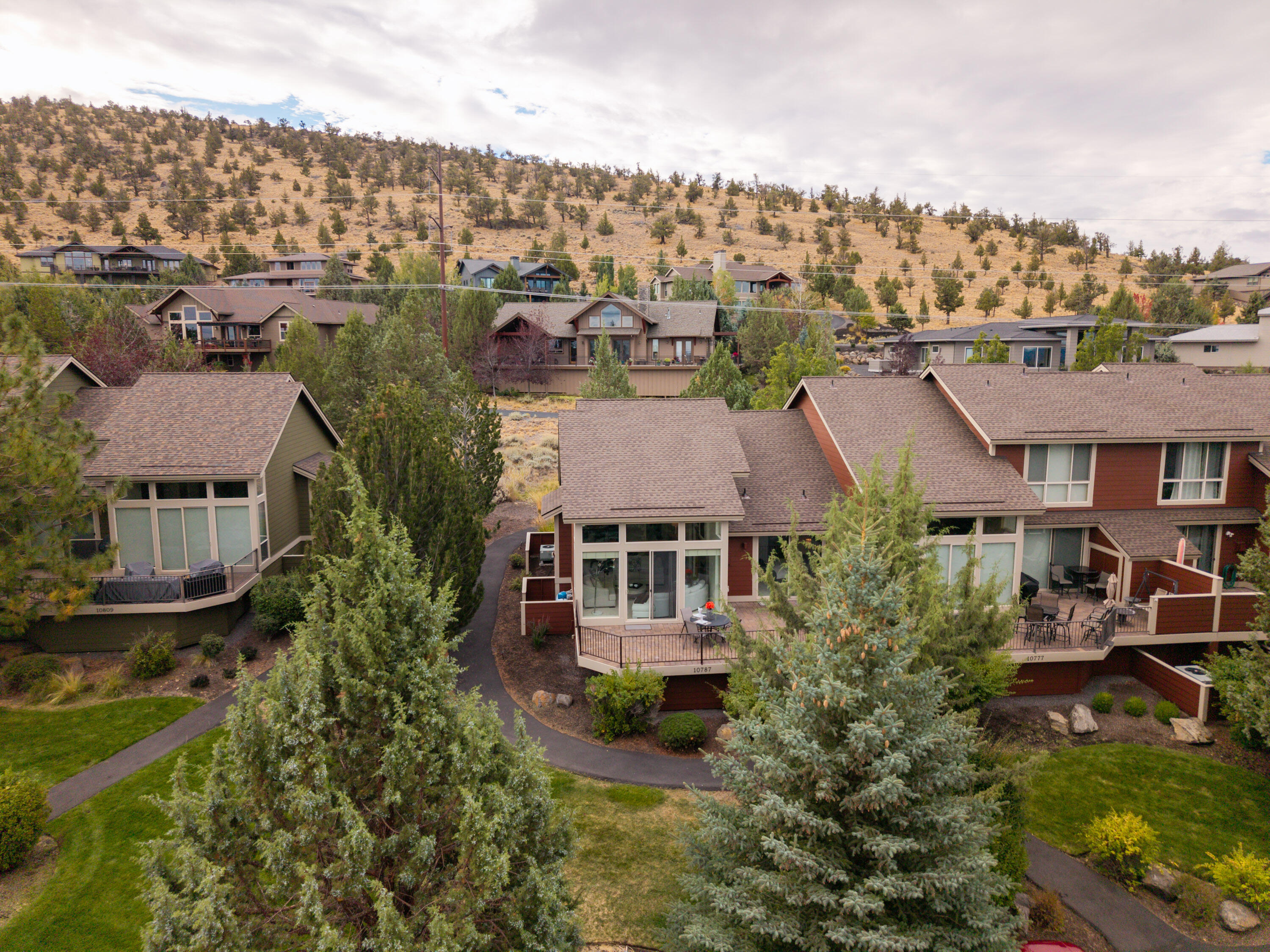 Highly upgraded single level end unit Creekside Village townhome with amazing privacy and an elevated view of the neighborhood and surrounding terrain. Upon entering the foyer, you are greeted by a light and bright great room layout with abundant windows, new carpet, fresh paint, and nicely styled entertainment area with integrated propane fireplace. The kitchen has granite counters and new high-end stainless appliances. Vaulted ceilings frame a huge wall of windows and sliding glass door that lead to the expansive paver patio with wiring for a hot tub, storage, and access directly to the primary bedroom. The primary suite fits a king bed with comfort and has an updated double vanity, soaker tub, shower, enclosed toilet, and a closet with new washer/dryer. Up front there's a large guest bedroom with adjacent full bath that functions as a guest ensuite. This is by far the best value available in Eagle Crest and won't last long!