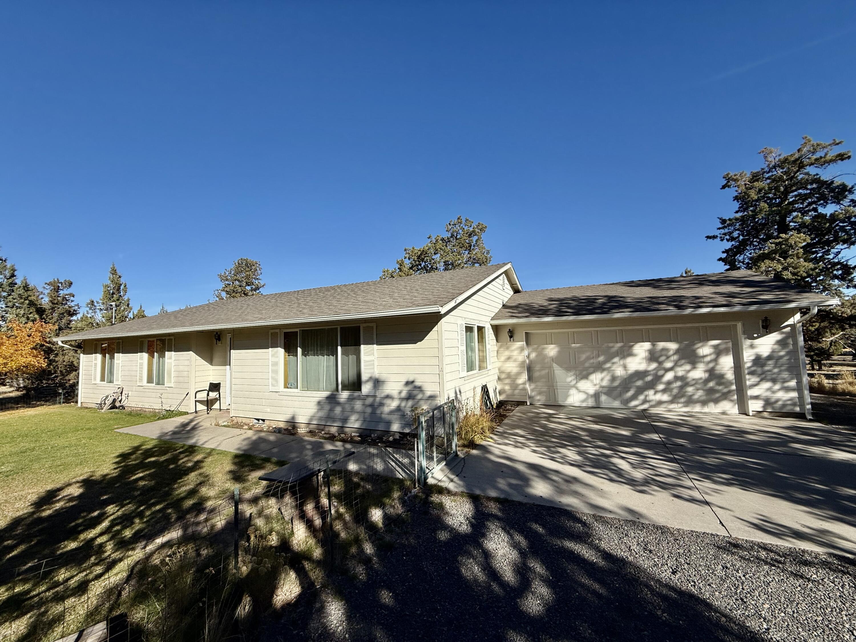 Discover peaceful country living in this traditional ranch-style home set on 4.9 level acres, offering space, privacy, and endless possibilities. The property features a spacious layout, fully enclosed front and backyard, multiple entrances, and an additional detached garage/workshop—ideal for hobbies, gardening, farm animals, or outdoor projects. Enjoy the quiet surroundings and open land while being just a short drive from Redmond's conveniences, creating the perfect blend of comfort, functionality, and rural charm.