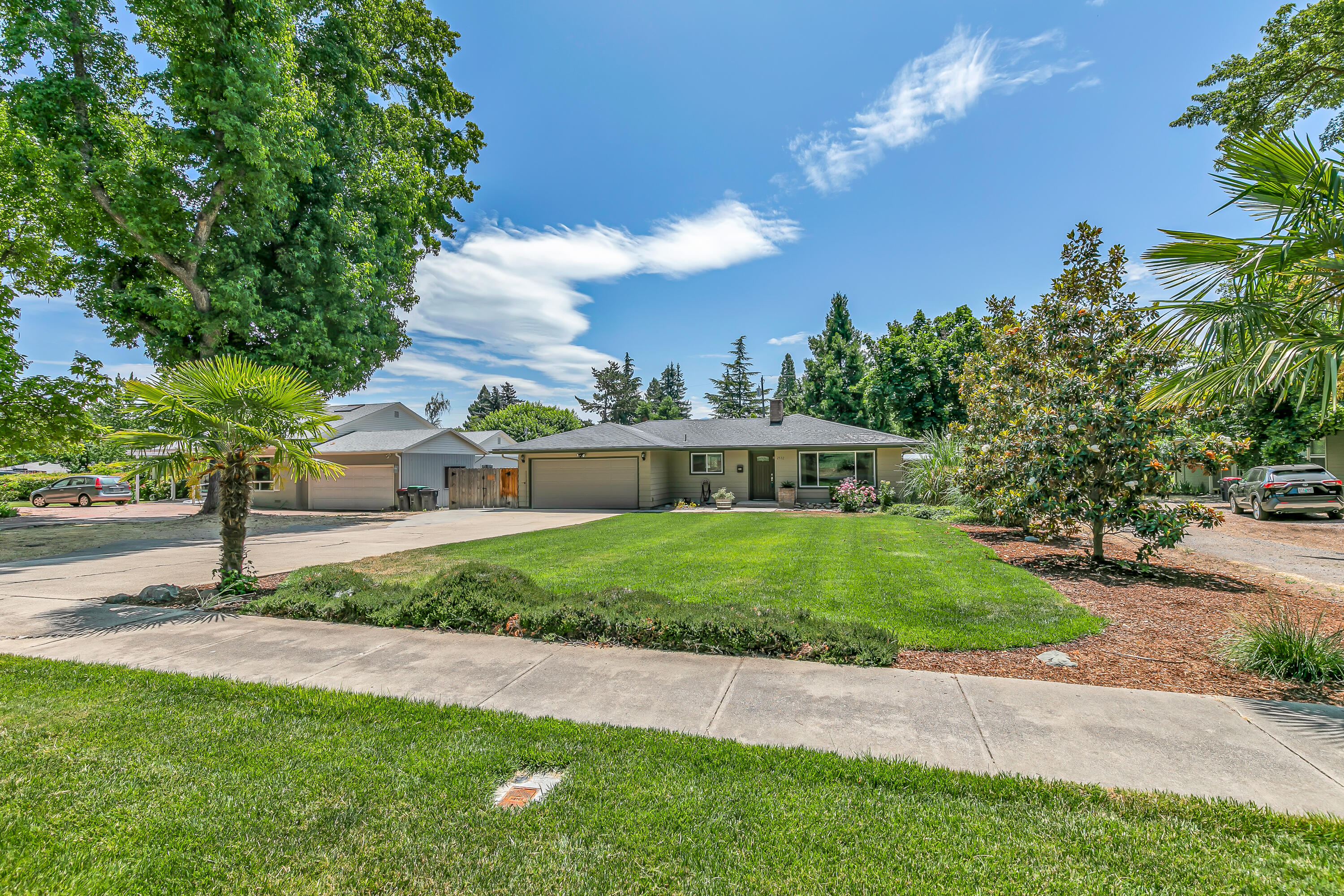 Updated Old East Medford with a huge yard, finished shop, and country club views! It's tough to find a better view than looking over the RVCC golf course right from the living room and kitchen sink. The large front yard sets the home far back from the street, providing nice privacy and plenty of parking, but there's still plenty of room out back thanks to the huge .34-acre lot. A double-wide gate leads to the spacious patio, plenty of parking for toys, and a generous yard with mature landscaping and room left over for a garden. But the real gem is the fully finished shop with dedicated power, vaulted ceilings, and a roll-up door - a rare find on this type of home! The interior of the home features a very functional layout with a breakfast bar in the kitchen and a fireplace and picture window in the living room, offering the perfect mix of comfort and coziness. With recent updating both inside and outside, this home is turnkey and ready to be loved by a new family.