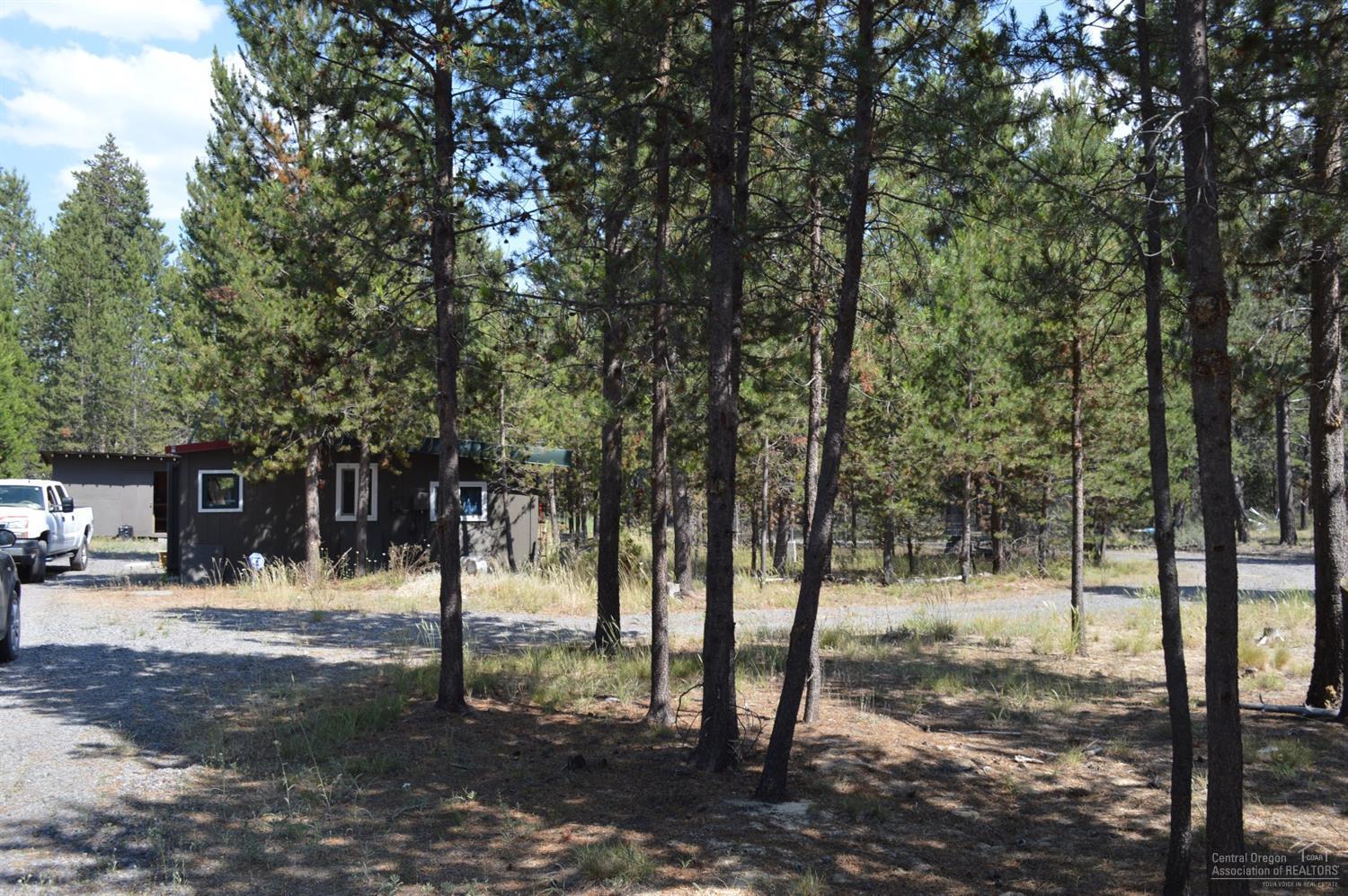 Great lot within walking distance to town. All utilities on property. Endless opportunities...you can stay in the cabin while you build or park your RV with the full RV hookups. Commercial/residential mixed use zoning. Pull through gravel driveway with gates on both sides. Call for owner willing to carry option.