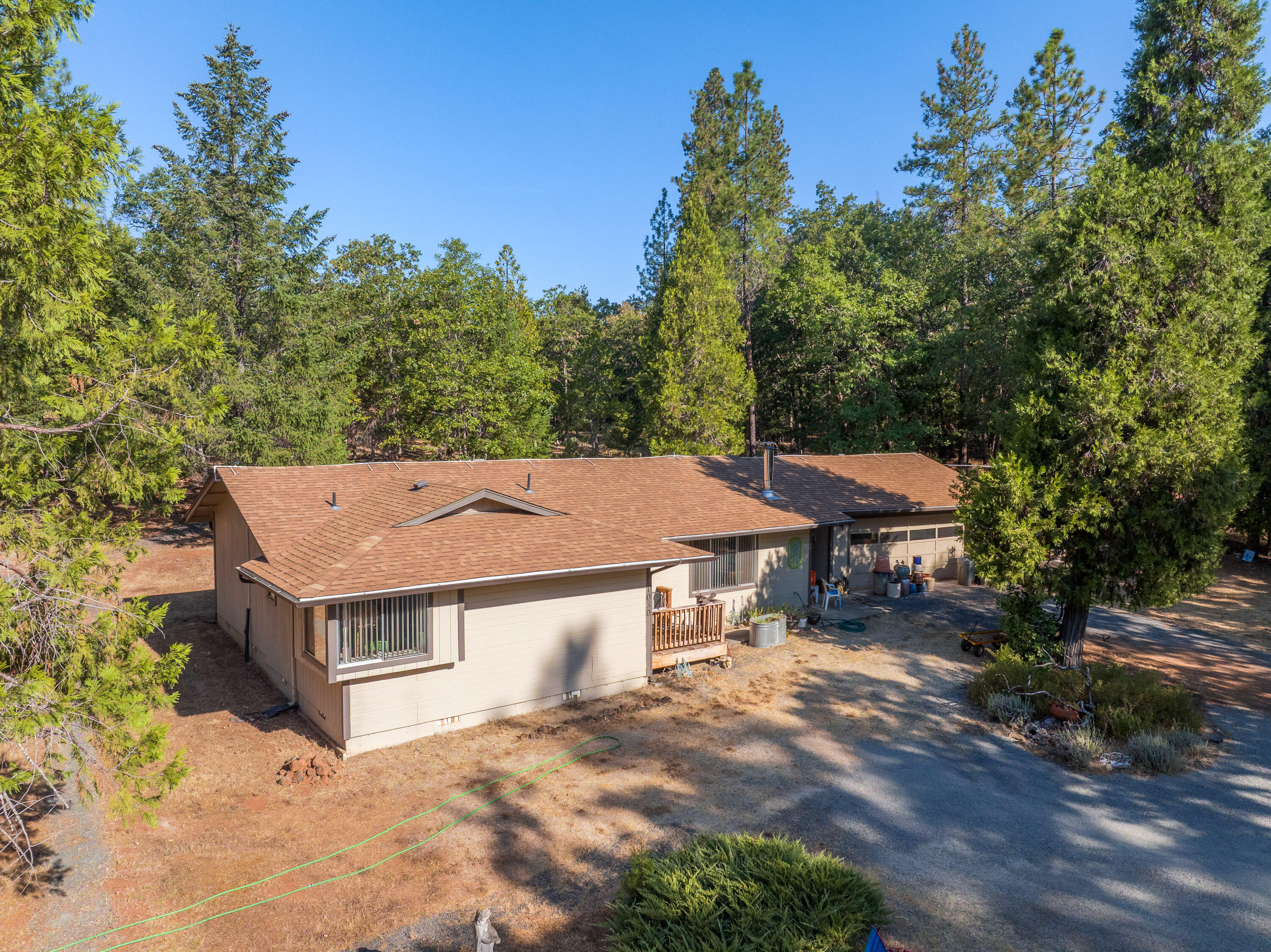 Discover this private country home with a large shop on 2.54 acres of usable land just minutes from town. This single-level residence features 3 bedrooms, 2 bathrooms, and a 2-car garage, plus an impressive 1,368 sq ft shop with its own electrical panel, finished office with A/C, high ceilings, and a 15-ft wide door. Inside, the oversized primary suite offers bay windows with abundant natural light. The kitchen, dining, and living areas flow in a spacious great room design anchored by a free-standing wood-burning fireplace. Recent upgrades include new flooring. Outside, the property is fully fenced with fire-safe landscaping, a fenced garden, a 2,500-gallon water holding tank, a seasonal 27,000-gallon pond, and a second well. Enjoy a rare balance of country living with modern convenience—ready for your next chapter.  Property is to be sold ''Where is/As is''