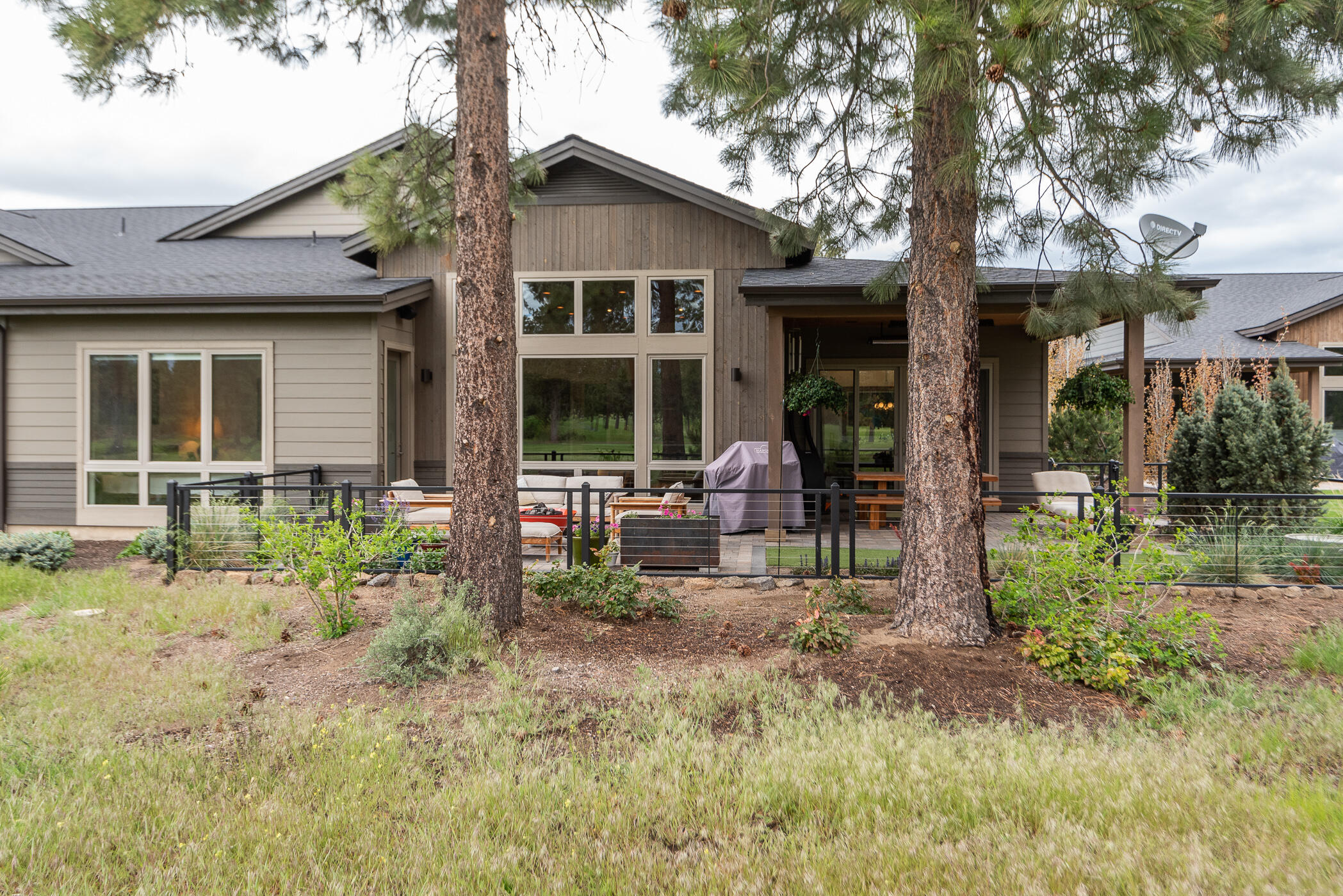 Welcome home to carefree living at 1925! Perfectly situated on the10th fairway of the Bend Golf & Country Club is a a gorgeous mid century modern, single level townhome. Incredible natural light with floor to ceiling windows that invite the outdoors in and overlook the expanded patio with a fire-pit and a water feature. Stunning tongue and groove wood ceiling featured in the entry and great room. Spacious gourmet kitchen featuring JennAir appliances, a wine fridge, quartz counters, desk area, a pantry and the perfect island for entertaining.The primary suite boasts dual vanities, soaking tub, steam shower and a customized walk-in closet. The junior suite and office are nicely separated from the primary suite. Hardwood and tiled floors throughout the home. Peaceful outdoor living with a fully fenced backyard, heaters and speakers to enhance your experience. The oversized 2 car garage has hanging racks and cabinetry as well as additional golf cart storage. Don't miss this home!