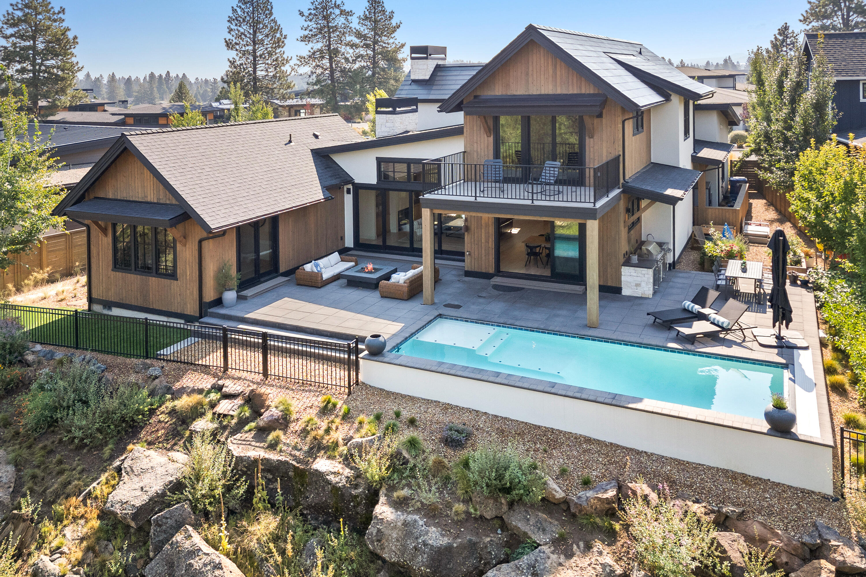 This spectacular mountain-modern home in fabulous Discovery West is located at the end of the only cul-de-sac in the neighborhood, offering wonderful privacy as it backs up to a natural park that will never be developed. This beautiful 4-bedroom residence features 3266 sqft of beautifully designed living space, which perfectly balances lifestyle comfort with entertaining. The open floor plan boasts soaring ceilings, along with a chef's kitchen loaded with top-tier appliances, stylish Dekton counter-tops, custom cabinetry, and a spacious walk-in pantry. The gorgeous primary bedroom suite is located on the main floor along with an additional ensuite bedroom and large office. 2 more bedrooms upstairs along with a bonus room and balcony overlooking the heated pool, outdoor kitchen and natural park below. Talk about energy efficiency...this home has a Tesla roof and 2 Tesla Powerwalls in the garage! This is truly a one-of-kind residence in Discovery West!