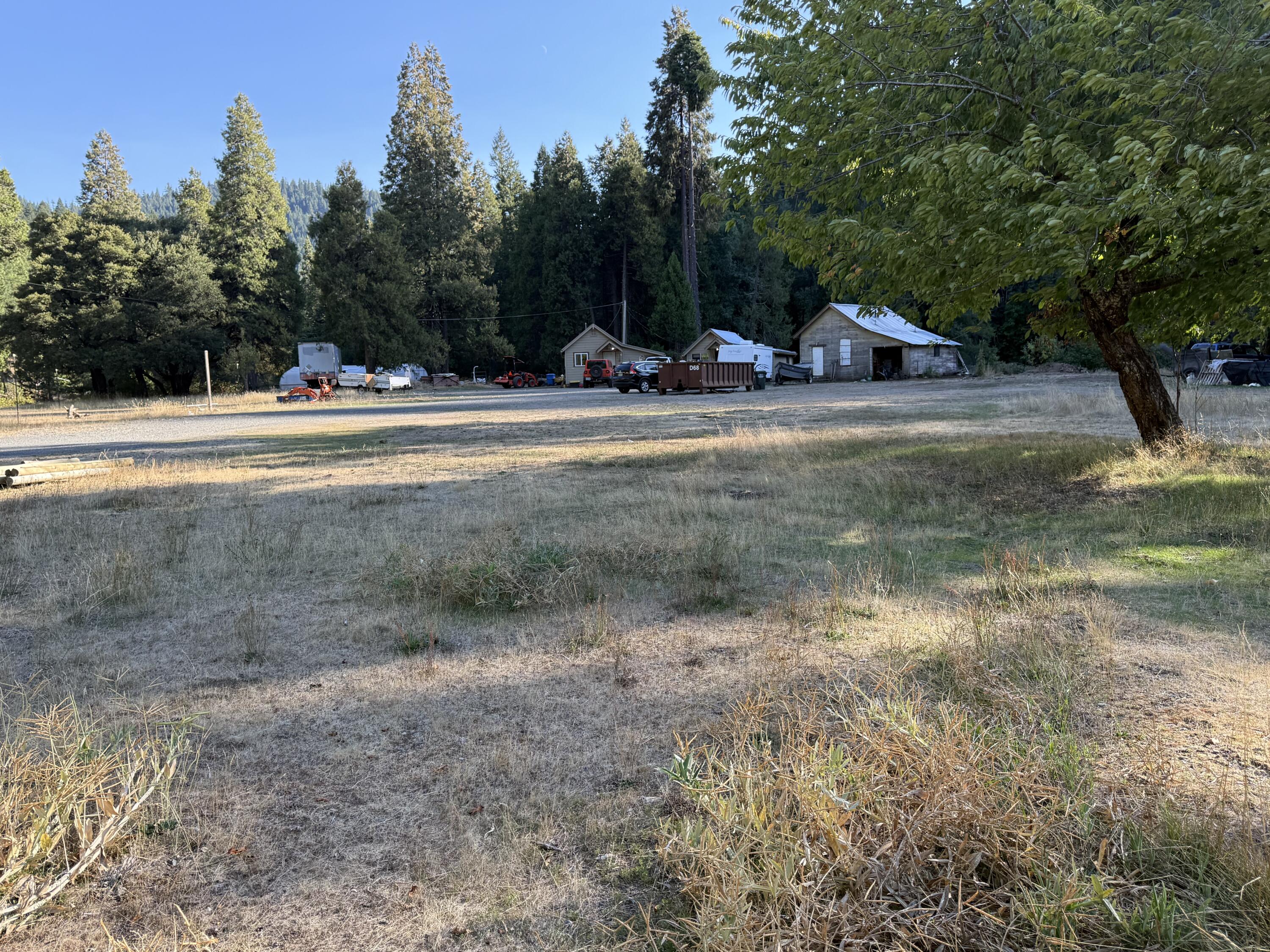 Got History??  Beautiful property with 2 cabins & one other building that was there when first developed many years ago. One Cabin,occupied, is very livable. The other needs to be finished renovated. There is a beautiful year round creek, that divides the property, that supplies irrigation rights for 18 acres, to  a large meadow near cabins. Commercial septic system (4,000 gal) and a unreal supply of water from a spring that is located on the property, for domestic use .
A large area below cabins, is  where a great garden spot could be located too. Serene setting, improvements way back off the highway, apx 11 miles to city of Cave Jct.  So much potential to develop a lot more uses. Truly one of a kind!