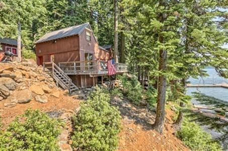 Lake front cabin on the west side. Cute & cozy with river rock fireplace in living room & wood lined walls plus rustic wood beam accents on ceiling. Brand new tile flooring in entry. Vaulted ceilings in bedrooms. Fresh exterior paint. Large deck overlooking the lake. Complete with boat house & dock! Year-round recreation: swimming, fishing, boating, waterskiing, jet skiing, hiking (Pacific Crest trailhead nearby), snow shoeing, snowmobiling (over 300 miles of groomed trails) & cross-country skiing. Resort area offers dining facilities, general store, marina & game arcade.