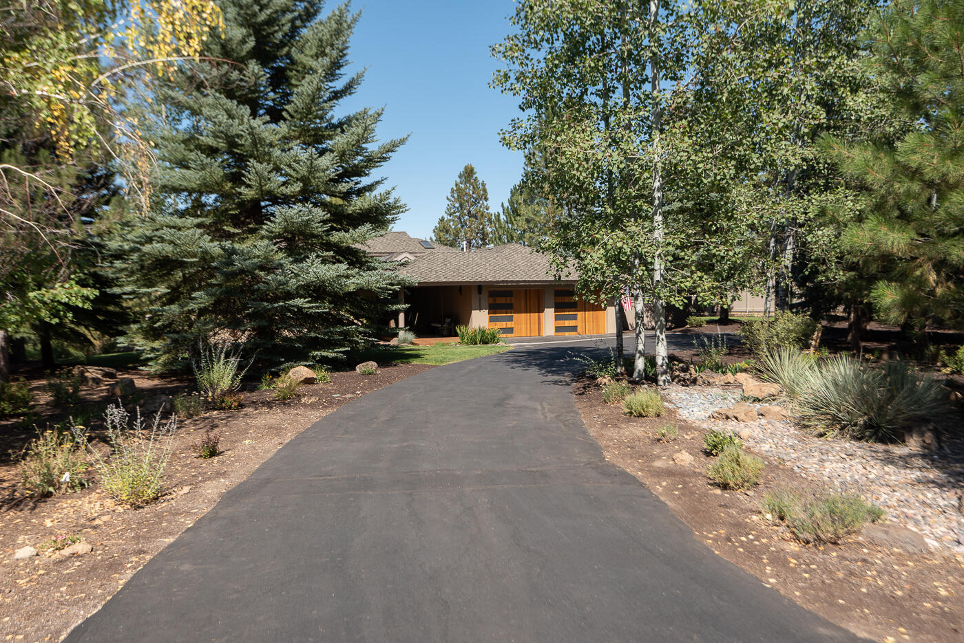 Stunning single level home in desirable Sunrise Village. Coveted gated community on Bend's Westside with private Deschutes River access, walking trails, pool, spa, clubhouse, park, tennis courts and RV storage. Nestled on a large landscaped lot with beautiful pine trees and Cascade Mountain views from Mt. Bachelor to Three Sisters. Expansive covered entry with skylights welcomes you to this light and bright open floor plan with soaring vaulted ceilings, accented wood beams, gas fireplace with floor to ceiling stone surround and windows to bring in the natural light along with beautiful views. Bright kitchen with island, quartz counters and ample storage. Large primary suite with vaulted ceiling and updated primary bath. Relaxing bonus room with access to side yard. Two guest bedrooms and full guest bath, office/flex space and an additional loft area. Expansive outdoor living areas with back deck and hot tub, wrap around paver patio with built-in fire pit and beautiful landscaped lawn.