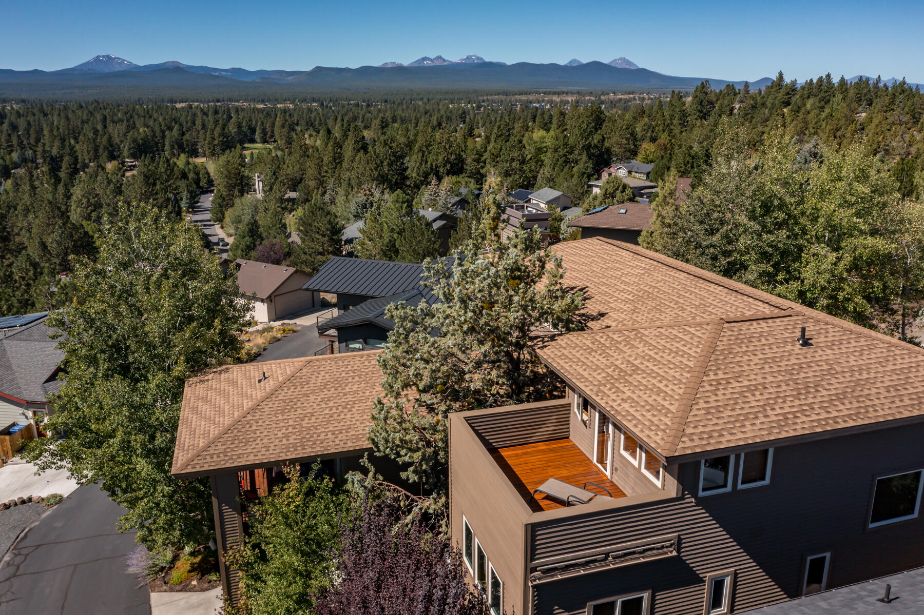 Perched high atop Golden Butte this exceptional custom home showcases sweeping southern vistas spanning from Pilot Butte to the Cascade Mountains. Thoughtfully integrated into the hillside it blends timeless Northwest architecture w/ meticulous craftsmanship. An expansive front deck complete w/ a striking lava rock waterfall sets the stage for quiet relaxation or Iively entertaining. Inside the welcoming living room is framed by picture windows & a dry stack wood fireplace w/ gas assist flowing seamlessly into a chef-inspired kitchen w/ a generous island & open dining area. A private covered deck off the kitchen invites year-round enjoyment. Comfort is assured w/ radiant floor heating, central AC & furnace. Vertical grain fir trim & doors add warmth throughout. Each level includes its own bedroom & bath, while the top-floor primary retreat offers 180-degree views, spa-like bath, walk-In shower, private deck & ample closet. Dual driveways & a 2 car garage provide privacy & convenience.