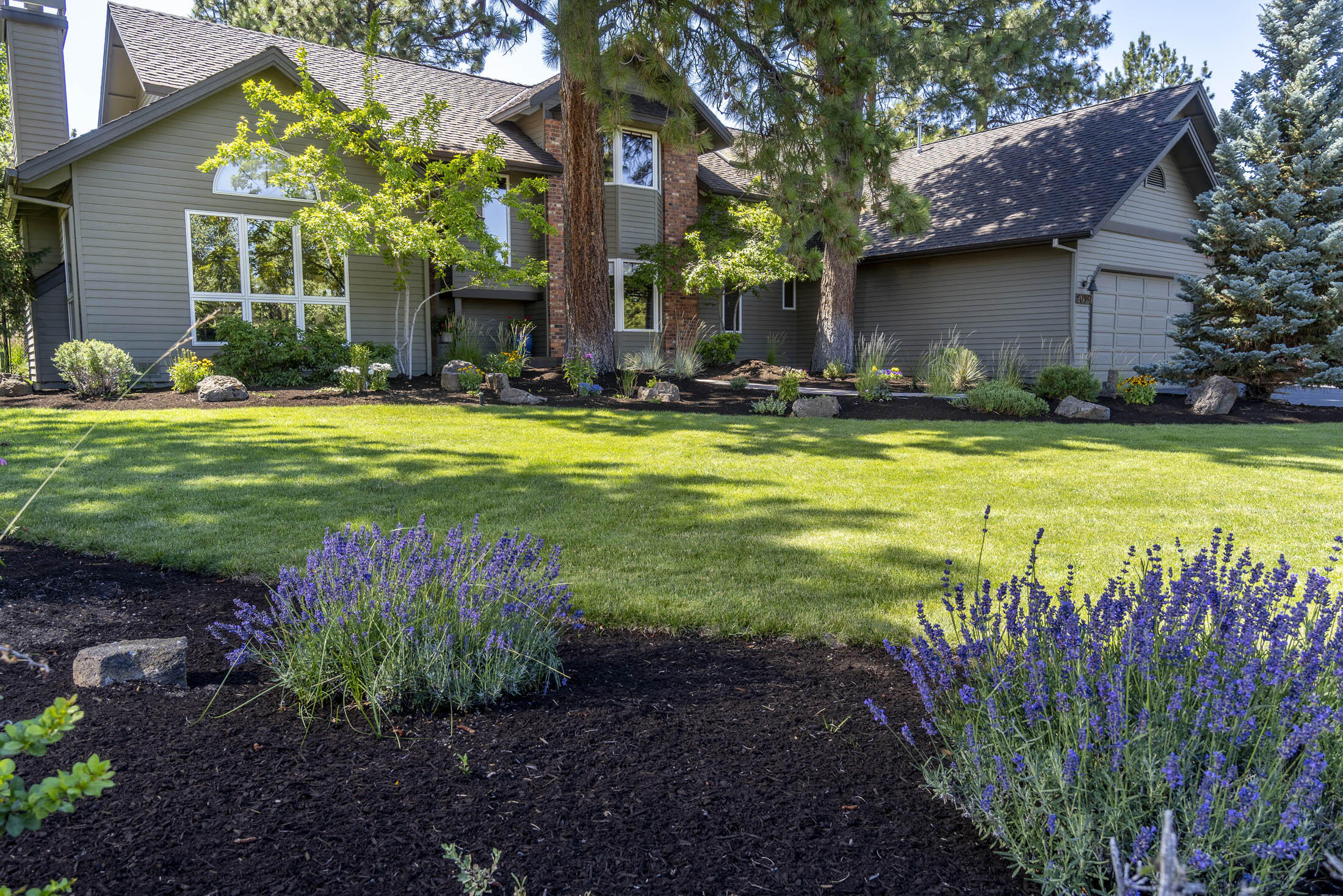Spectacular one of a kind! Take the long driveway into this beautiful landscaped 2.37 ac close in property located in the Woodside Ranch community in Bend. As you approach this 3004 SF 3 bedrooms, 3 bath home, you will appreciate the well manicured landscaping and mature trees that welcome you! The home's main level has a living room with vaulted ceilings and fireplace, family room, dining room, sunroom, main bath and laundry room. Main floor Primary suite offers lots of windows, deck access, large walk-in closet, and bathroom with dual vanities, walk-in shower and soaking tub. The heated floors are a bonus! The gourmet kitchen has Black SS appliances, gas cook top, center island with bar seating, granite and tile counter tops with a beautiful copper sink. Upstairs offers a spacious bonus room, office area, 2 bedrooms, full bath and large walk-in storage room.  A spacious 3 car garage with built in cabinets. Fully fenced backyard, sprinkler system, RV parking! Outdoor storage building.