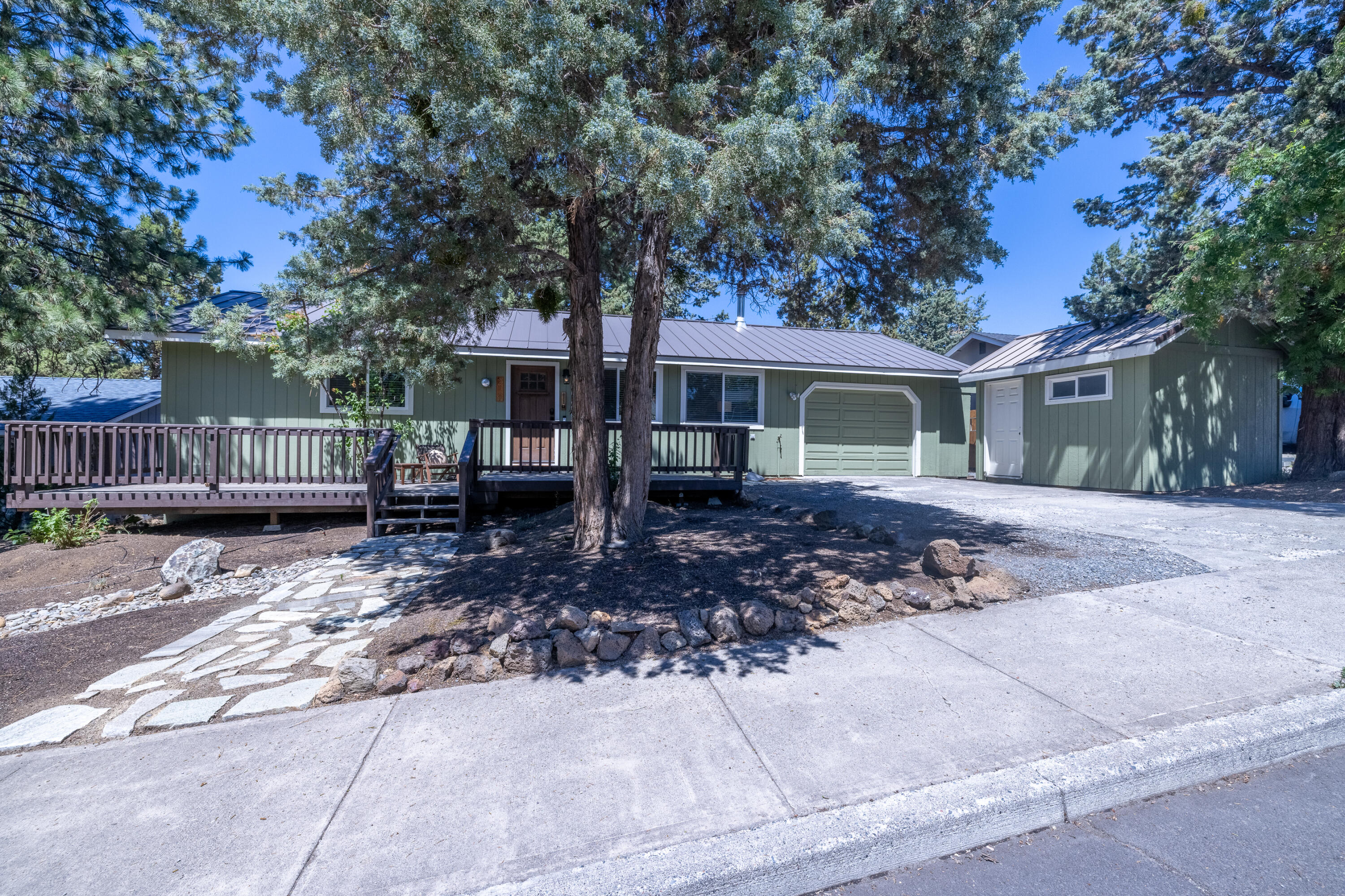 Nestled in a calm cul-de-sac, a short distance from the Old Mill, this home and its location represent the spirit of Bend. The open floor plan, featuring vaulted ceilings, butcher block countertops, and a large covered deck, create the perfect environment for entertaining or just having a relaxing evening. Within earshot of the amphitheater, you and your guests can experience various musical artists during concert season from the comfort of your home. A pristine backyard creates the ideal green space for yard games or spending the afternoon tending to your flower beds around the perimeter. Access to the nearby canal trail, only blocks away, allows great hiking opportunities without getting in the car. When it's time to run errands or get out into the woods, the central location allows easy and quick access no matter the direction you're headed. The extra deep garage, large front outbuilding and two additional outdoor storage spaces offer plenty of room for all your Central Oregon toys