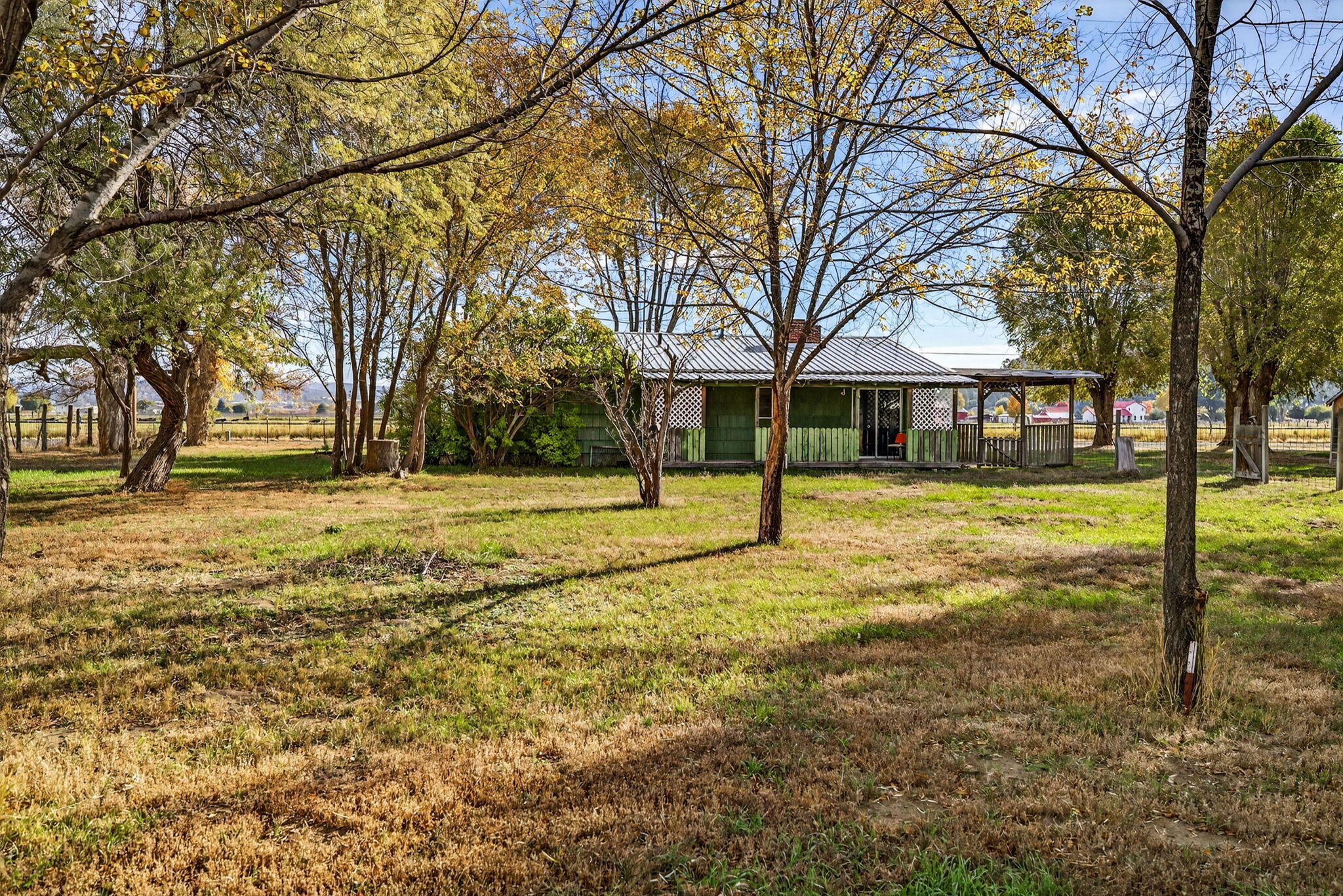 Welcome to your private slice of paradise! Nestled on 7.57 beautifully fenced and cross fenced acres, this 3 bedroom, 1 bath home offers peace, space, and the kind of breathtaking views that make you never want to leave. With 1,408 sqft of living space, you'll appreciate the oversized living room and generously sized bedrooms. The home is served by 2 wells and includes a single car garage for added convenience. While the home could use a little love and updating, it offers incredible potential to create the rural retreat of your dreams. Also included on the property is the original homestead, full of character and ready to be brought back to life as a guesthouse or second living space. Located just minutes from town, you'll enjoy the best of both worlds: close to amenities , yet feeling worlds away. This is more than a home- it's an opportunity to build your dream lifestyle.