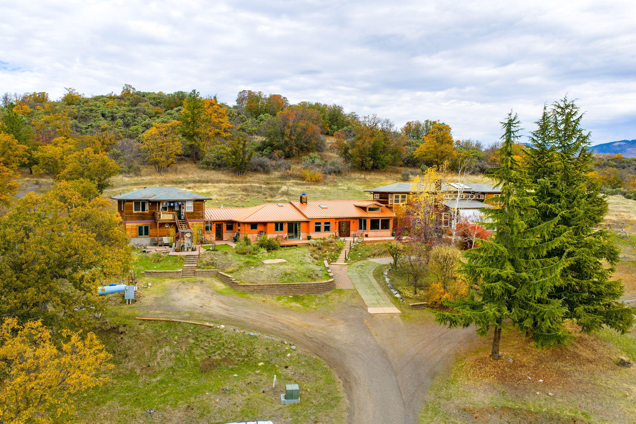Welcome to your own oasis: a truly unique property offering 3 living spaces on nearly 5 peaceful acres w/ beautiful mtn & valley views 5 minutes from downtown Ashland. Whether you're seeking a multi-generational home, income-producing rentals, or a private retreat, this property provides incredible flexibility. The main home (built in 2011), blends creativity & comfort w/ American clay walls, radiant heat floors, & an open-concept layout filled w/ light. The spacious kitchen is ideal for entertaining, flowing seamlessly into a large living area w/ tranquil mtn views. It features a large primary suite on the main level, an additional bedroom/office, and a great room — perfect for family gatherings or guests. Connected yet distinct, the original home offers 3 bedrooms, 2.5 baths, & a large multipurpose room w/ a passive solar sunroom. A separate studio apt w/ a private entrance adds even more versatility. Outside, enjoy the rolling pasture, vineyard, garden space & breathtaking views.