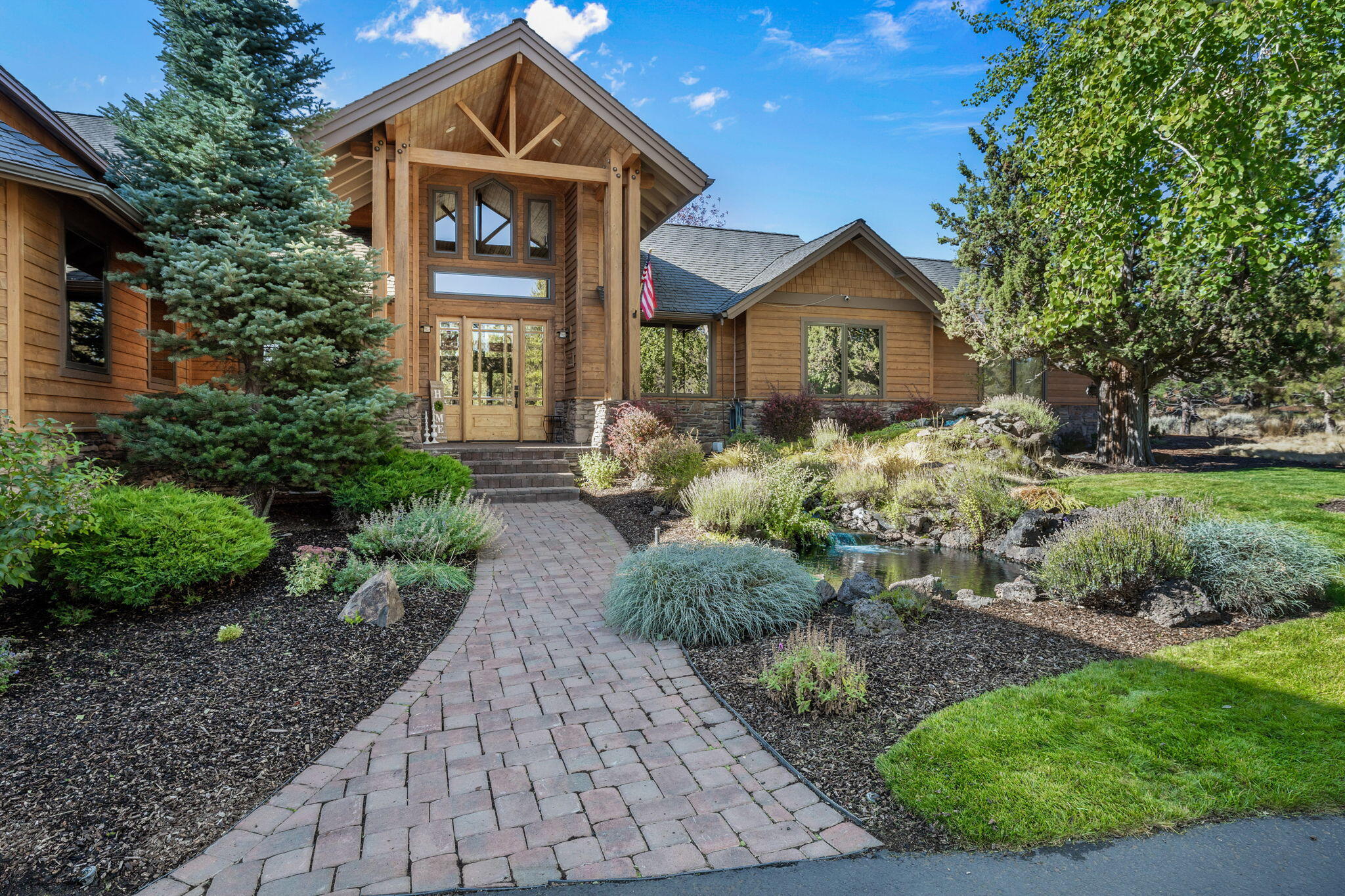 This stunning updated upcraftsman home, located in Aspen Lakes Golf Estates, is on the 14th hole. The grand two-story entry immediately welcomes you w/warmth & charm with all the fine touches you expect. Cathedral ceilings, rich hickory floors, custom built-ins, & a floor-to-ceiling stone fireplace.
The gourmet kitchen is a chef's dream, featuring a professional Wolf range with six burners, double ovens, & Subzero refrigerator making it the heart of the home. The primary bedroom wing is on the main level, & offers a spa-like ensuite with a soaking tub, spacious tiled walk-in shower and spacious WI closet. Step onto the patio to enjoy panoramic views of the Sisters, gorgeous sunsets, or starry nights. Just off the entry is an optional guest wing that makes a perfect in-law suite w/a living area, bedroom, bath, & private patio. The office boasts built-ins, & work surface. Additional loft area & 2 bedrooms upstairs. Five space garage w/workshop! Just minutes from downtown Sisters.