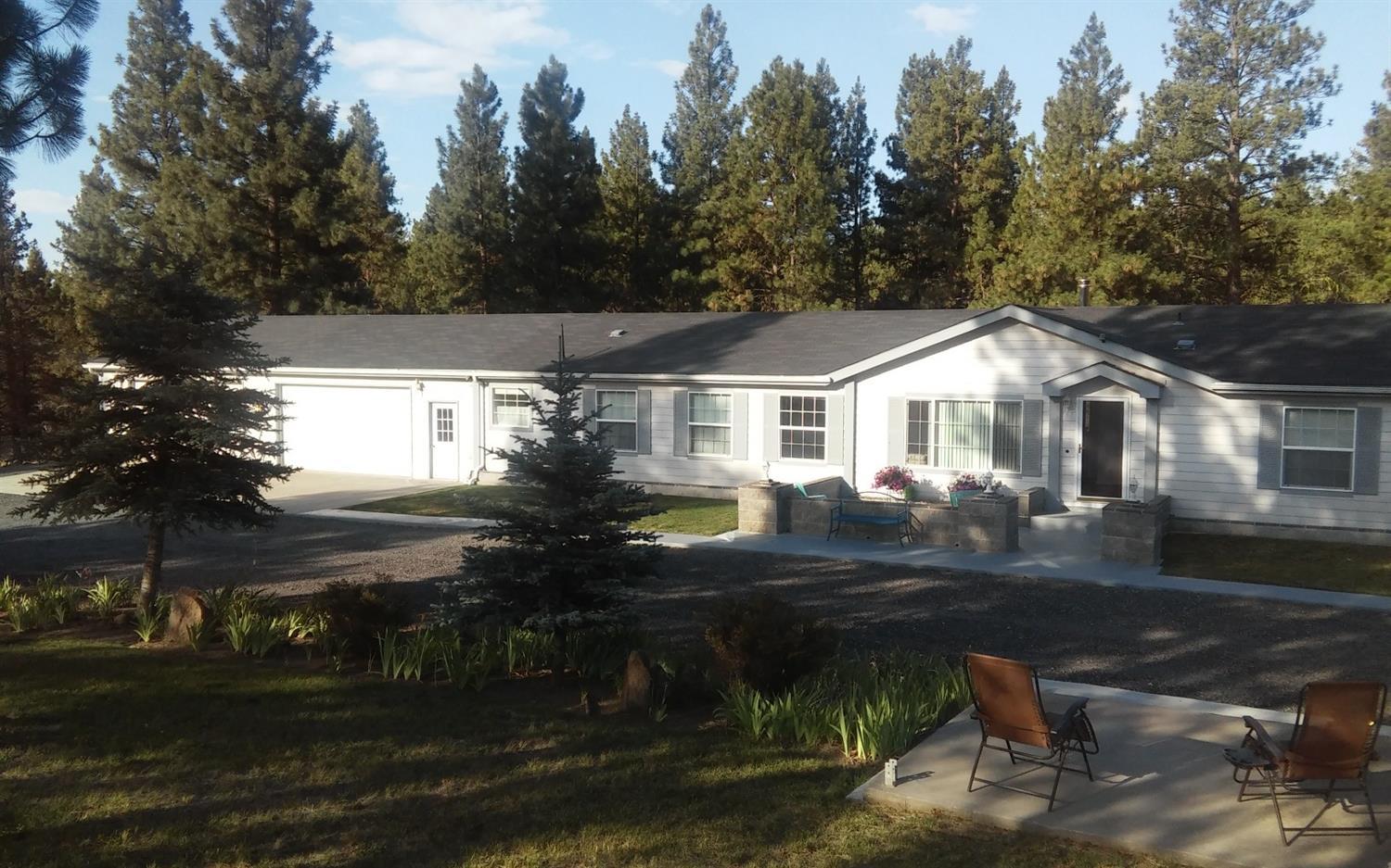 Home sits on 2.34 acre of wooded land with an additional 2.48 acres across the street that has been DEQ approved for standard septic, in area of good wells and has power pole with upgraded transformer on the property. 2005 Manufactured Home. Large master bedroom boasts a sitting room, walk in closet, en-suit bathroom with soaking tub and walk-in shower. Split floor plan with additional 3 bedrooms and guest bath. Large kitchen with island and lots cabinets for storage. Enjoy the afternoon breeze on the back deck over looking your own seasonal pond. Well built chicken coop and 4 car garage/shop, RV parking and room for all your toys.