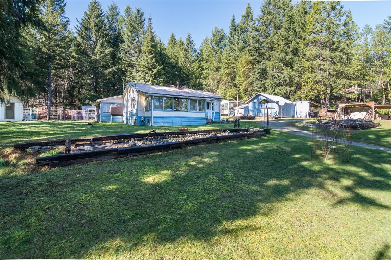 This forested setting is flat out beautiful: 1.57 mostly usable acres ringed by soaring pines, located just one mile from the center of people-friendly, small-town Glendale. The completely liveable two bedroom/two bath home was built in 1946 - it's not at all fancy, but everything works. The well is high-producing, the galvanized roof keeps it cool in the summer without air-conditioning, and a modern oil heating unit makes it super comfy in the winter. It's also fully piped and ready for any size wood stove. The back and side yards feature large garden areas, a vintage green house, a sturdy little barn, ample space for RV parking, plus several small sheds for tools and storage - which will come in handy while spiffing up the grounds. In front, the lawn slopes gently downhill towards Section Creek, which babbles year 'round just past the property line. So give it a huge make-over - or build your dream home here. This is an as is sale - conventional financing or cash.