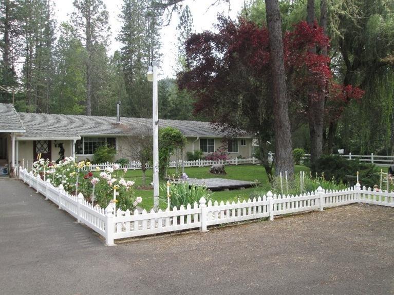 Spacious 3 bedroom, 2 bath home on 2 level and beautifully manicured acres, on private access road. Home has large enclosed screened porch with tile floor for the summer evenings and an attached workshop. Detached Studio for guests with its own bath and access. Additional features include 2-car detached garage, fenced and covered dog run, two 2-car carports, one by house, one by Studio. Two wells, one for house and Studio (8.4 gpm), one for irrigating lawn. RV parking and hookups in front of Studio. Paved driveway, vinyl fence around front yard, deer-fenced garden and rose garden. Seller is a licensed real estate Broker. Make this your new home!