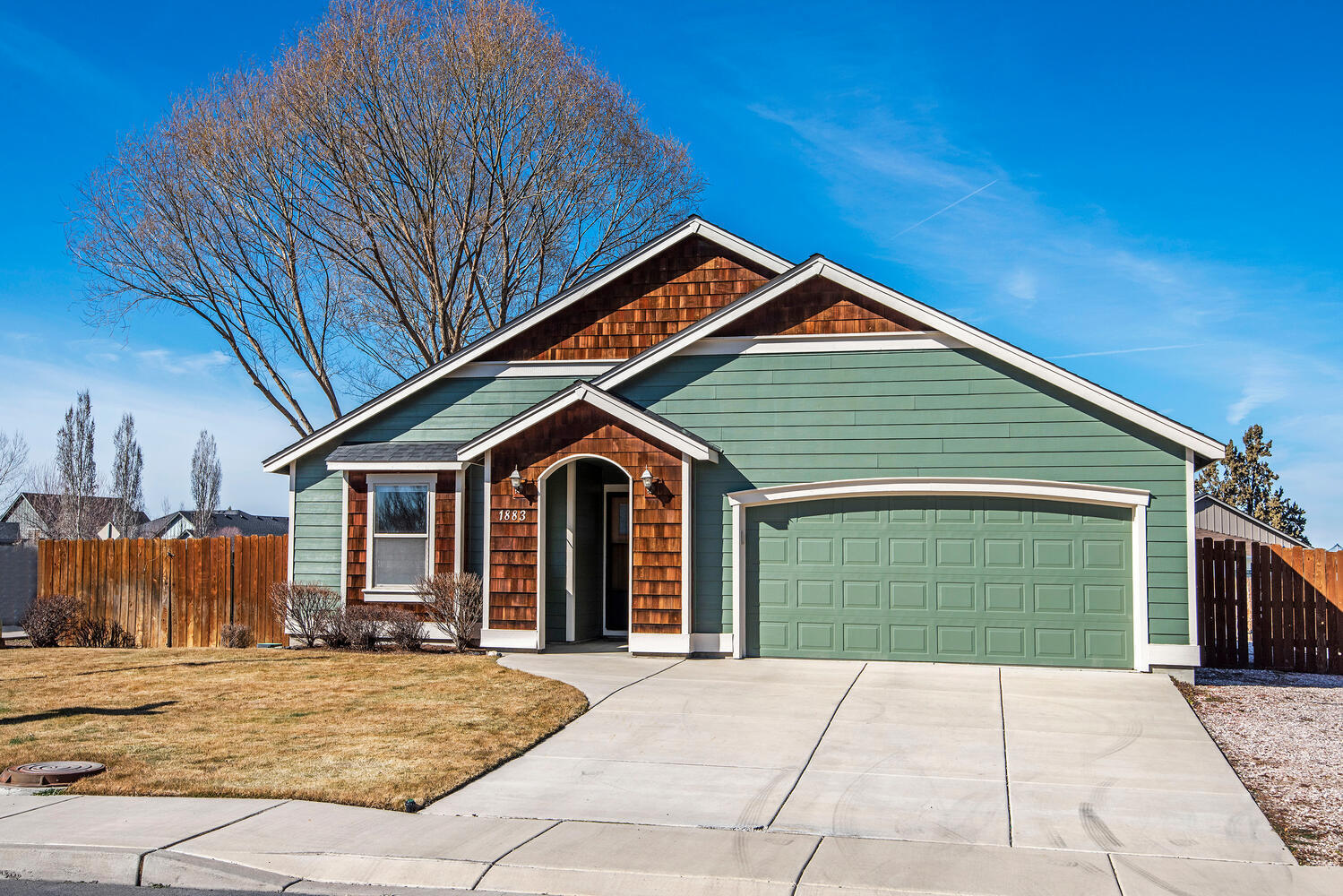 This former model home is on a quiet cul-de-sac that is s short distance to the Dry Canyon. The front porch is covered. Soaring ceilings & big windows inside let plenty of natural light in. Built-in bookcases surround the fireplace giving the home depth and character. The kitchen features stainless steel appliances, rustic alder cabinets & porcelain tile countertops with maple floors that are shared with the breakfast nook. Durable slate floors are in the entry and laundry room. The primary bedroom has a walk in closet, double sinks and a walk-in tiled shower. The backyard patio is enclosed. The yard is landscaped and fenced. On the east side of the yard is a large area to park your RV or boat, maybe both.