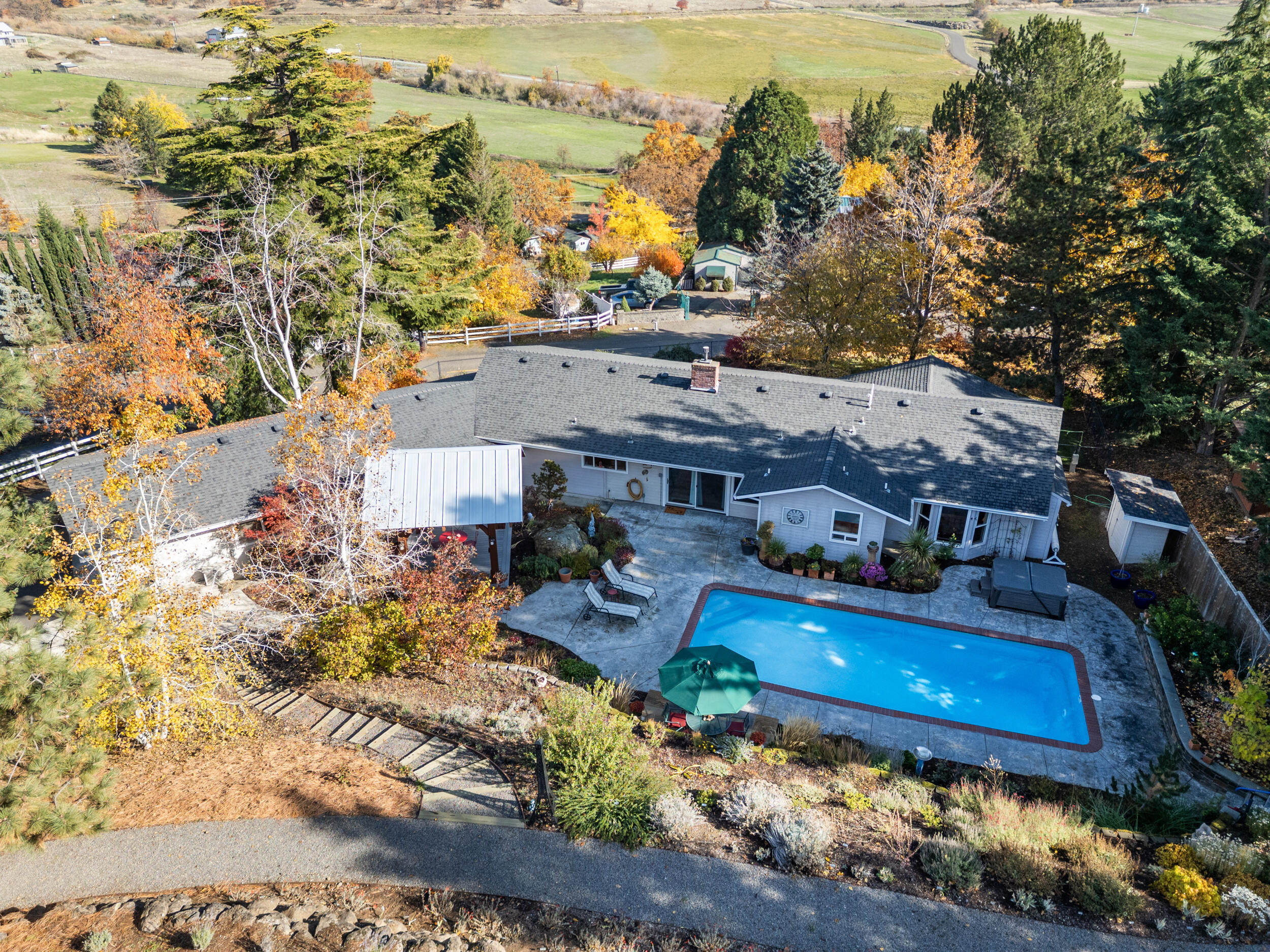 If you've been searching for that perfect Southern Oregon retreat, this is it. Set on a gentle knoll with views & privacy, this single-level home is minutes from Talent, Ashland, & Medford. Enjoy an in-ground pool surrounded by gardens, fruit trees, irrigation rights, & a timber frame pavilion, plus a detached, climate-controlled shop that rivals the home itself. The open floor plan includes a chef's kitchen with granite counters, stainless appliances, six-burner range, & three ovens. Spacious living & family rooms offer comfort & entertaining space, along with an office. The primary suite overlooks the pool & gardens, featuring a jetted tub, tiled shower, & dual sinks. A detached two-car garage with cabinetry completes this exceptional Southern Oregon property.