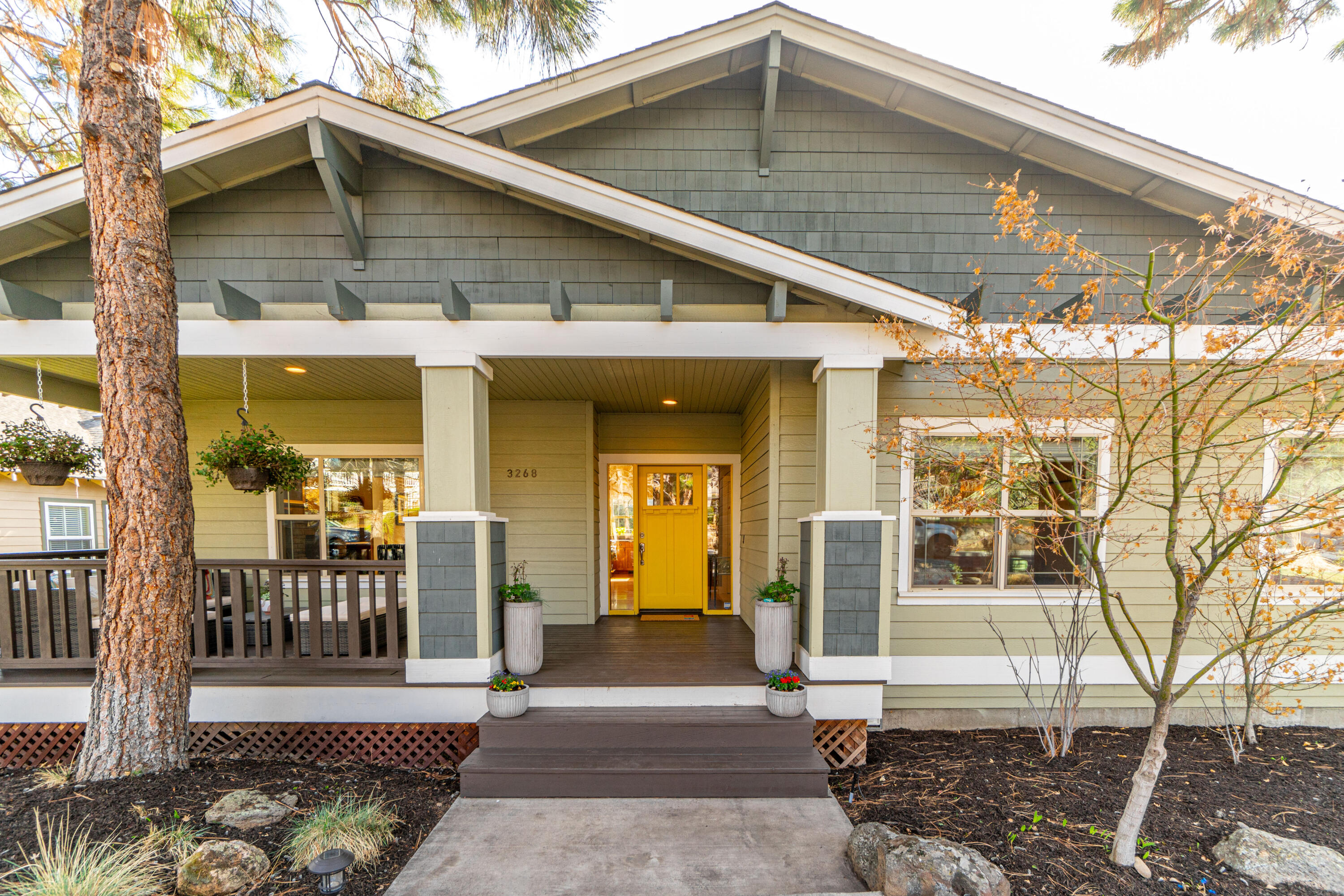 Welcome home to NW Bend in Awbrey Village!  A 3 bed, 2.5 bath, 2303 sq/ft stunning contemporary craftsman home awaits along this quiet tree lined street.  Thoughtfully remodeled to highlight the vaulted interior with clerestory windows providing warm natural light, elegant hickory hardwoods throughout, and a remarkable built in stone hearth gas fireplace. Ample sized dining connects to the elevated back deck with airy treed views to the east. The center point kitchen with breakfast bar, quartz counters, & tiled backsplash opens to both the living & family rooms on either side. Nice bright windowed primary suite with a spacious tiled bathroom, dual vanity, pebbled walk-in shower, soaking tub & WIC.  Two additional bedrooms, full bath, powder & laundry room complete the main level. Downstairs a tuck under tandem 3-car alley load garage with extra storage & off street parking for van lifer's.  Hang under the covered front porch and enjoy low maintenance easy living in a terrific location!