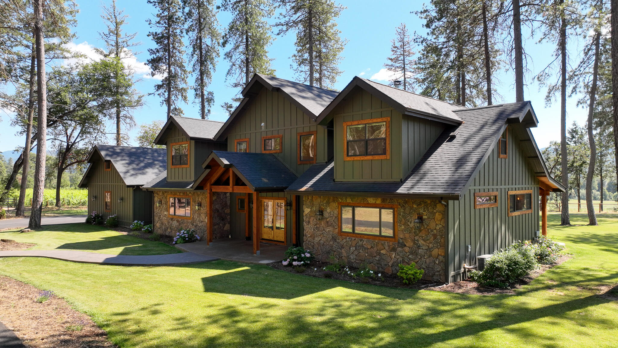 Magnificent 4 bedroom 3.5 bath custom built home with salt water pool and a charming park setting in the heart of the Applegate Valley. This dream of a kitchen features stainless appliances, 6 burner gas stove, spacious pantry, granite counters, kitchen island, large copper farm sink, pot fill and soft close drawers. Master bedroom located downstairs with step in shower, soaking tub, double vanity sinks, massive walk in closet and a view. The open floor plan allows a view of the grand fireplace and picturesque windows overlooking the fully landscaped backyard and neighboring vineyard. Upstairs features a 2nd laundry room, full bath and 3 additional bedrooms. 5 garage spaces! 3 car attached with full bath and storage/shop space and a detached 2 car garage with carport and room for your RV. Hardwood floors and stunning knotty alder finishes throughout this must see home. Too much to list and this home comes nearly furnished. All information deemed reliable but not guaranteed.