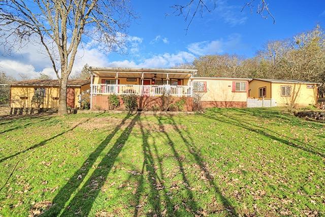 Great family home with rural feel just 10 minutes from downtown Grants Pass! This 3 bedroom, 2 bath manufactured home is wheelchair accessible and boasts a welcoming front porch. In addition to the main home, there is a detached 2 car garage AND a 400 square foot accessory bedroom/studio/artist's retreat. The accessory bedroom was built in 2010 and has its own water heater and an ADA accessible shower. All of this on 1.18 acres that is fully perimeter fenced! This home and property is just waiting for someone to make it their own!