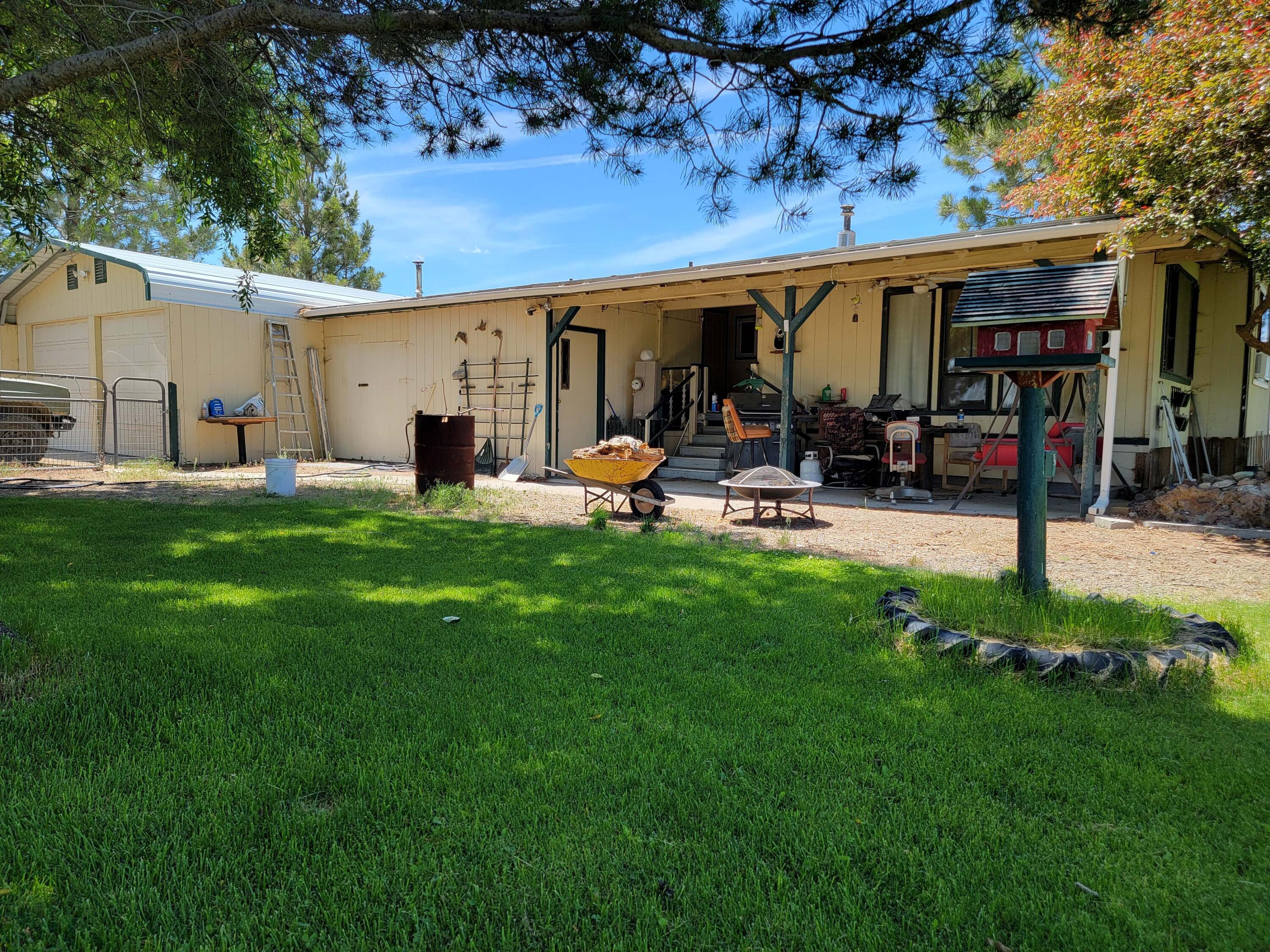 Nearly 1-acre (.97) property featuring a spacious 2-bedroom, 1-bath 1972 manufactured home with open-concept living. Living room includes pellet stove, new laminate flooring, and wood accent beam. Generously sized kitchen with ample counter space and storage. Both bedrooms offer comfortable space and good-sized closets.

Exterior features include a covered patio, mature trees, fire pit, water feature, and fully fenced and cross-fenced yard—ideal for animals. Attached 2-car garage with breezeway access. Additional improvements include greenhouse, RV shed, two conex containers, and a tool shed.

Located within driving distance of Christmas Valley Sand Dunes, Crack in the Ground, and Fort Rock State Park, offering abundant outdoor recreation. Property offers excellent space for animals, storage, and recreational toys. Schedule your showing today.
