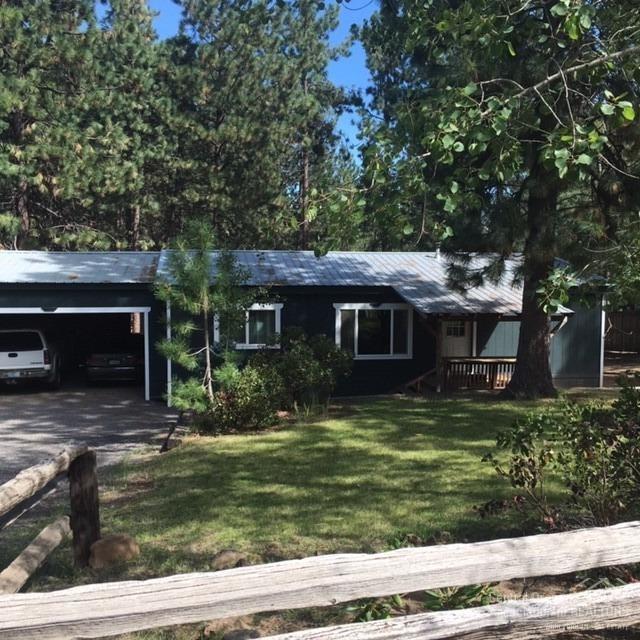 Cozy affordable home in Deschutes River woods on over an acre of land. Just minutes to downtown Bend. This home has 3 bedrooms and 2 bathes the master suite has plenty of room with a full bath. Covered front porch and a big back deck overlooks the large treed backyard with fire pit, shop with covered wood storage. Also, a separate storage shed. Attached 2 car 3 sided carport. All on a quite street.