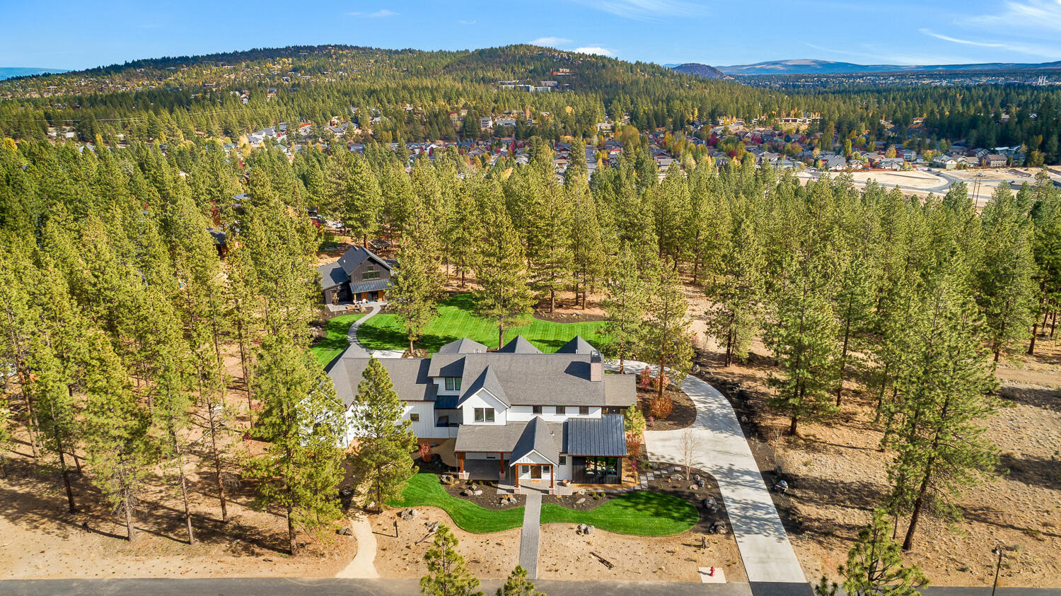 This absolutely captivating 4066 SF custom home & 934 SF guesthouse plus 440 SF office are sited on 2.5 acres in west Bend's coveted Westgate neighborhood adjoining Shevlin Park. Built in 2020 with a nod to the modern farmhouse, this home combines rustic accents, uber-efficient design, abundant natural light & beautiful finishes at every turn. Two story great room flows to kitchen with enormous quartz center island, breakfast bar & dual gas ranges. Plentiful storage in walk-in pantry & separate mud/gear room. Additional main level rooms are ready for art, library or school space. Open staircase & balcony lead to vaulted primary suite with extensive storage, 2nd ensuite bedroom, 2 add'l beds & jack & jill bath. Large attic rec room provides more living space. Oversized 1760 SF 3 car garage with 37' 4th RV bay.  Charming 1 bed, 1 bath guesthouse with loft, covered patios & storage, separate 2nd floor office & 625 SF of garage space. Easy access to trails, parks & National Forest.