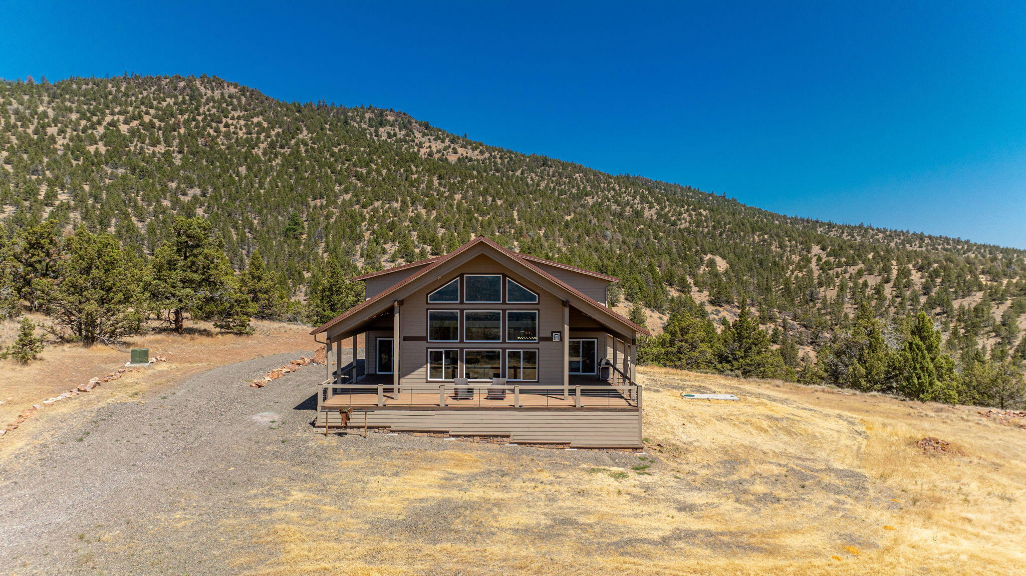 Back on Market- NO FAULT OF PROPERTY. MOTIVATED SELLER! Privately situated on Grizzly Mountain, just minutes from Downtown Prineville, this 65 ACRE retreat offers a stunning, peaceful setting, modern rustic charm, & sweeping Cascade Mountain views. Built in 2019, the 4BR/3BA home offers an open kitchen w/dramatic wood slab island, stainless appl, solid surface countertops and walk-in pantry. Exquisite Great Rm filled with natural light, features a wall of windows framing the panoramic views, floor-to-ceiling stone fireplace, warm wood accents and soaring ceilings. 2 Main Level en suite bedrooms. Upstairs: Spacious Bonus/Game Rm and 2 additional bedrooms. 1,141 SF 3+ car garage. Property boarders 785 acres of BLM land creating more privacy than you could ever imagine. Three 2,500-gallon cisterns, 500-gallon propane tank, 1,000-gallon septic, and ideal solar slope. RV hook-ups. Land Owner Preference (LOP) hunting tags available. STR eligible. An awe-inspiring property and a must see.
