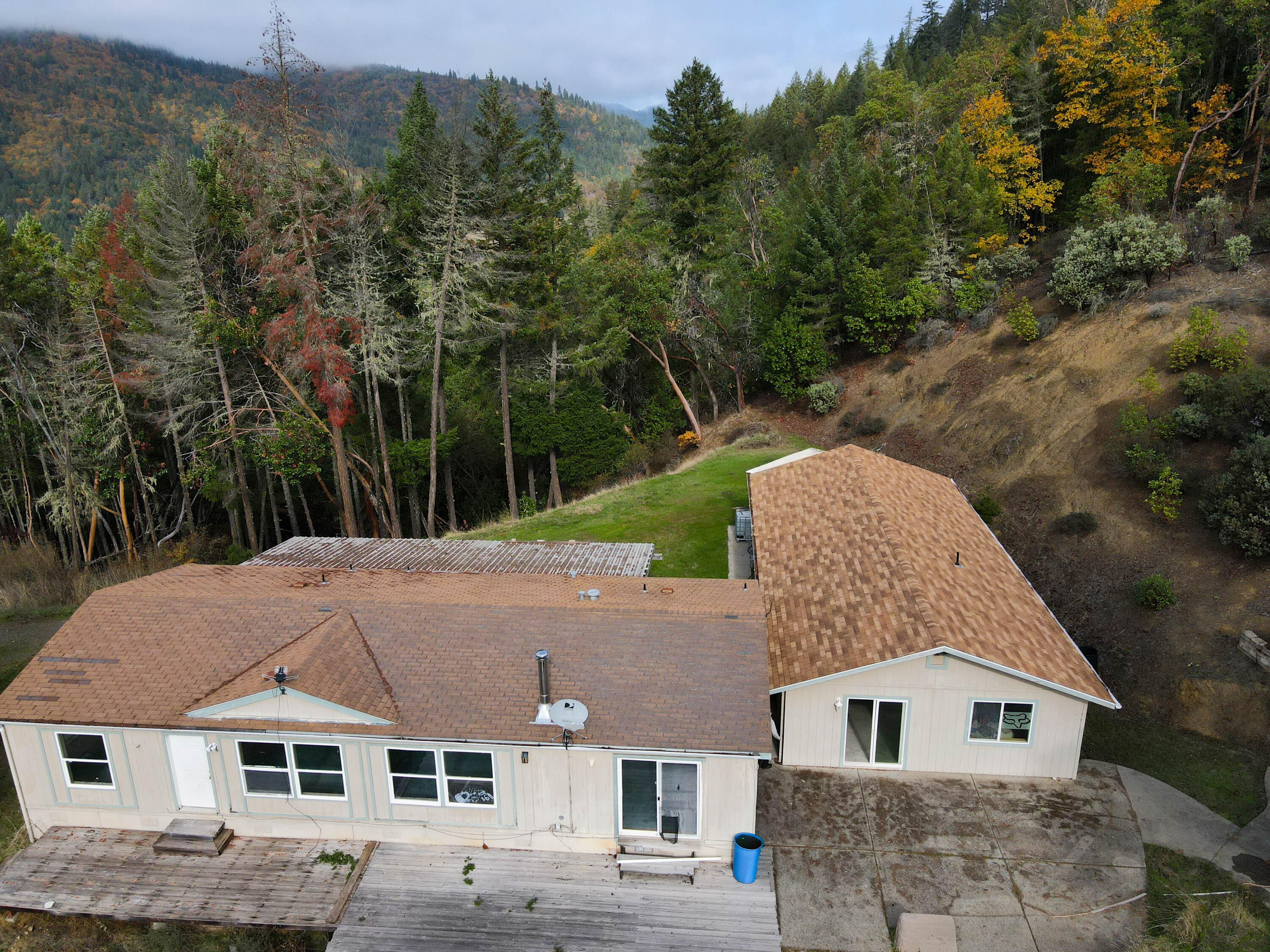 Located above Rogue River, this 1,512-sq-ft, 3-bed/2-bath mobile home sits on 20+ wooded acres with long private frontage and wide territorial views. The floor plan includes a living room, dining area, and an efficient kitchen with good storage. The primary bedroom has a walk-in closet. A second bedroom and full hall bath support guests, office, or hobbies. Utilities and access are straightforward, and there is space for RV parking and equipment. An oversized three-car garage provides covered parking plus room for a shop and gear. The acreage is largely timbered for shade and wildlife, with a mix of usable areas for gardens or expansion. Location offers privacy while remaining a short drive to Rogue River services and I-5. If you need square footage, a true three-car garage, acreage, and reliable views in Southern Oregon, this property checks the boxes.