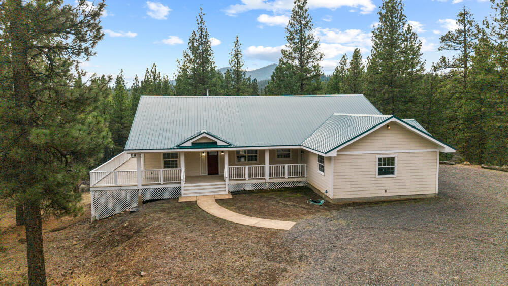 YOUR VERY OWN TREEHOUSE!!  Brand new Custom Home, 1920 sf with 3 BR, 2B, large laundry room, attached 2 car garage ALL on 6.29 acres of Pine Trees. Borders USFS forest for great recreation and privacy.  Special features of this home: slate tile entry with ledger stone wall, hardwood floors in the dining, living rooms & kitchen.  Open floor plan for great entertaining space.   Large French doors from living room open onto the large covered deck-forest type view and Saddle Mountain. The Primary bedroom also has French doors onto the covered deck, recessed lighting. Attached bathroom with travertine stone floors, jacuzzi tub, custom rustic alderwood cabinets & walk in closet.  Upgraded carpet in all 3 bedrooms, hall bathroom with travertine stone walls and floor.  Gourmet kitchen with all new appliances & solid oak cabinets.  Lots of storage in the large 8 ft. granite island and counters, recessed lighting and walk in pantry. Large laundry room with enough room for office space,crafts.