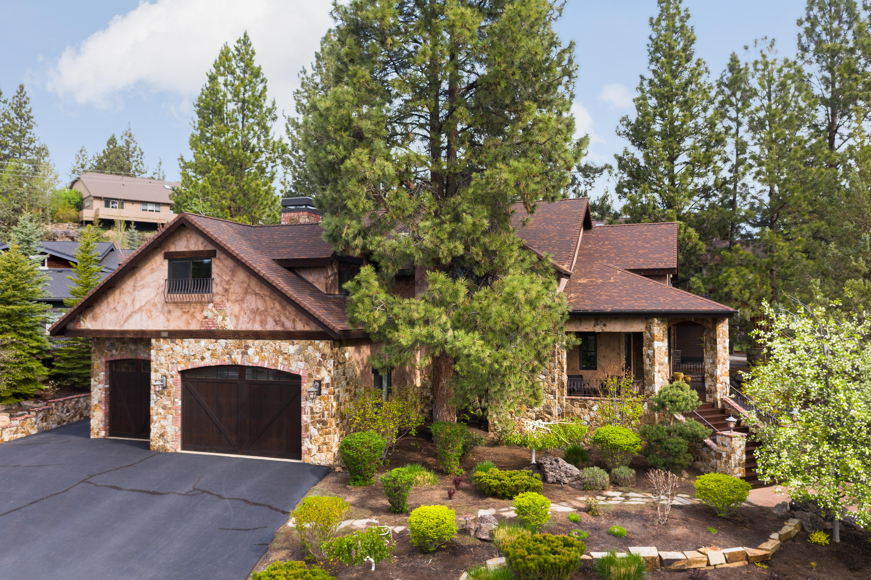 A reflection of Tuscan & Northwest design, this iconic Shevlin Ridge Neighborhood home is admired for its architectural integrity and beauty. The timeless stucco exterior is further defined by the abundant use of natural Montana Gold stone and brickwork, arches and a grand gabled roof line. A stamped concrete walkway leading up to a large entry and porch deck made of Ipe Brazilian Walnut. Superior interior finishes include knotty Alder cabinetry, slab granite counter tops, beautiful hickory wood floors, gourmet kitchen with center island, built-in wine & serving bar with brick & stone surround and a stunning limestone fireplace in the gathering room. Plus the 4th bedroom/studio has its own sitting area & bath. The exterior flagstone patio courtyard is highlighted by a stone wood burning fireplace with gas starter plus a stone staircase to a private, arbor enclosure with sitting area. Enjoy music outside with your guests from the exterior speakers. The perfect place to relax & unwind.