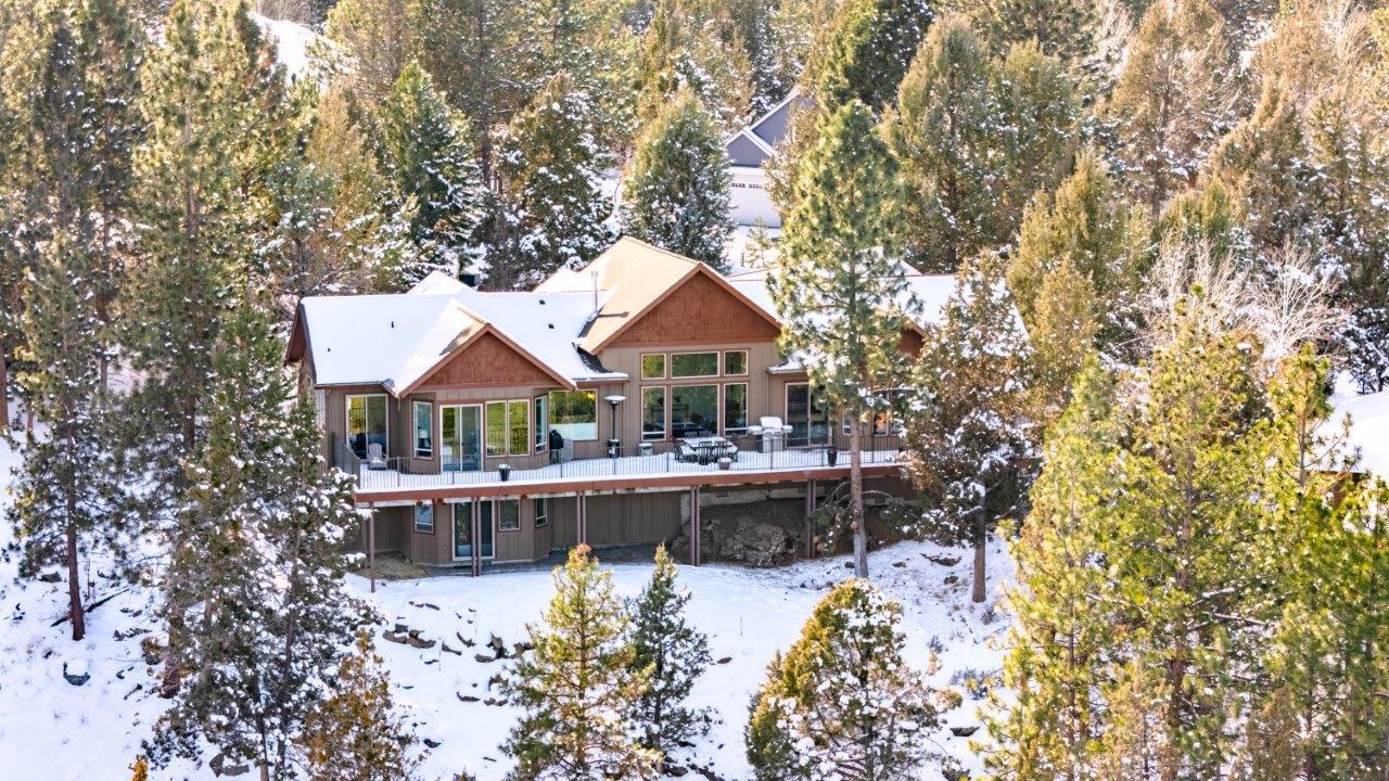 Located behind the gates of one of Bend's finest neighborhoods, this home offers the serene views and optimal layout you desire. Entering the home, you're greeted by natural light and an inviting great room adorned with a stone fireplace and gleaming wood floors. Across the room, towering pines beckon, and a wall of windows draws you in. From the living room perch, Smith Rocks & the Ochoco's come into focus. The views continue to the kitchen, conveniently appointed with island bar seating, pantry, & veggie sink. Gorgeous views welcome you into the office and primary suite on the east wing, while the west wing holds 2 guest bedrooms. Laundry room, powder, and a guest bathroom are also on the main floor. Downstairs you'll find a bonus room, guest bathroom, and 2 large rooms ideally suited for storage. Situated on a generous, one-acre lot, perfectly positioned on a rise to capture the scenic views. This special home sits above the 12th fairway.