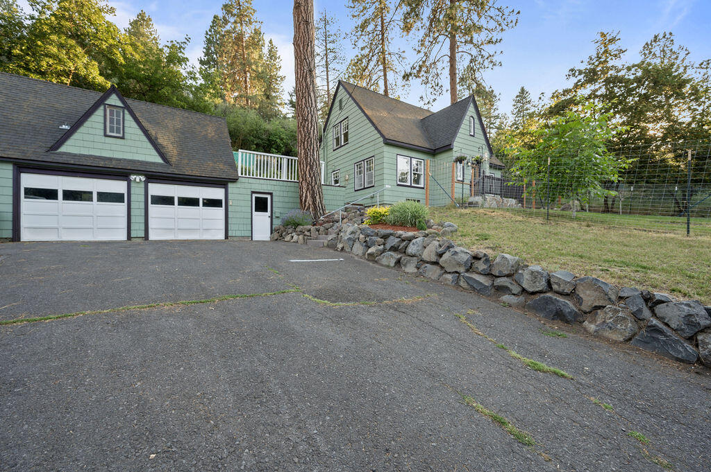 Appealing home with traditional design and numerous updates throughout. Open living/dining area with wood floors and beautiful stone fireplace with gas insert. The stunning kitchen has granite counters, 5-burner duel-fuel range with double ovens.  The spacious primary bedroom has vaulted ceilings and walk-in closet.  The on-suite bath has double sinks and jetted tub. Large, finished basement with full bath, built-in bar and ample room for all activities. Double car garage has enclosed breezeway from the house.  Above the garage, with separate entry is added living area for extended family, or a studio apt with small kitchenette and full bath. Currently the Sellers rent this through Airbnb for added income. Large front yard with patio and fenced area for pets/garden. Dog kennel and chicken house in back with a stairway path for hiking.  NEW SEPTIC TANK AND DRAINFIELD.  NEW GAS F/A FURNACE!