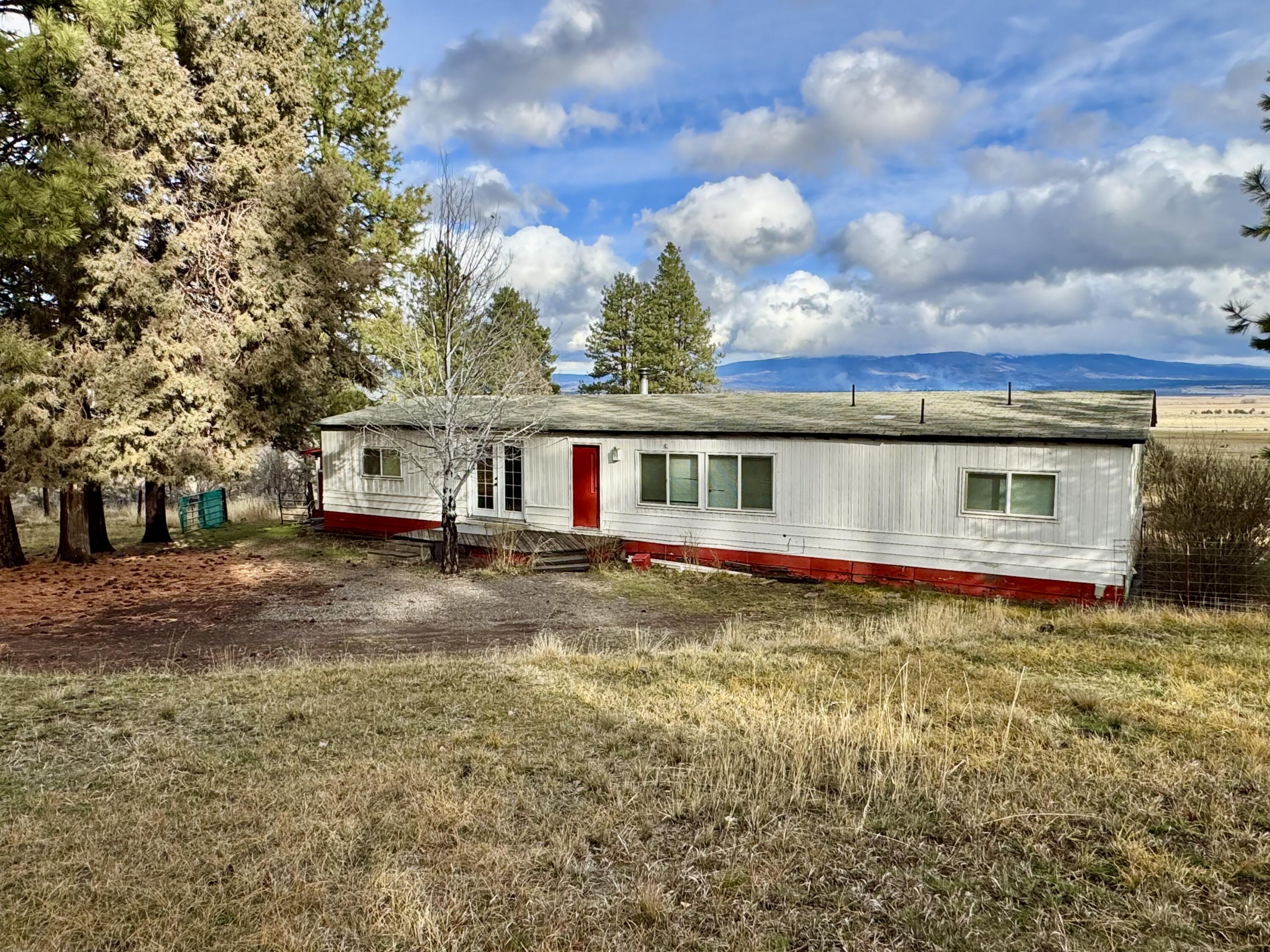 Set on 1.05 acres in the peaceful Bly area, this 4-bedroom, 2-bath home offers space, privacy, and scenic surroundings. The property includes a small fenced pasture behind the home along with additional fenced areas, making it well-suited for small livestock or hobby farming. A small workshop and a larger shed provide plenty of room for storage, projects, or equipment. Surrounded by mature trees, the property enjoys beautiful views and a quiet rural setting. With solid potential and room to personalize, this home is a great opportunity to enjoy country living on acreage.