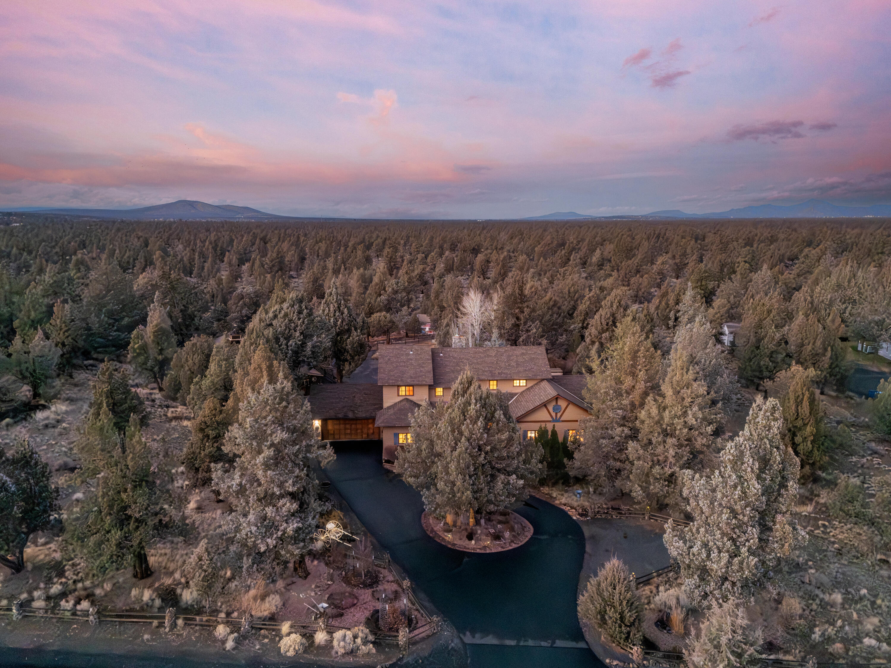 Set in the quiet Boonesborough area and backing to BLM land, this beautifully developed 2.67-acre property offers privacy, open space, and everyday convenience. The 3,321-square-foot home features four bedrooms and three baths with light-filled living areas, warm wood flooring, timber accents, and a pellet stove accenting the living room. The well-appointed kitchen offers generous workspace and storage with a functional layout. An expansive new Trex deck extends outdoor living and connects to a patio beneath a gazebo, ideal for entertaining or quiet evenings. The landscaped grounds include a pickleball court, tranquil pond, and Scandinavian cook house. A 2,200-square-foot garage includes a finished activity room, shop, space for RVs or boats, and an electric vehicle outlet. A fenced corral with covered stalls provides flexible use. Located near shopping, dining, the airport, and trails, this property captures Central Oregon living with room to unwind and explore.