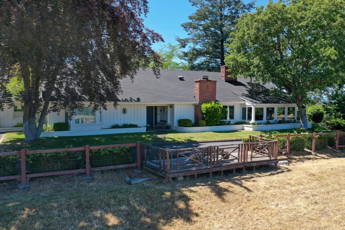 Elegant Yet Comfortable Mid-Century Ranch Estate with Spectacular Valley and Mountain Views. Imagine expansive, one-level living on this 23.88 acre irrigated property just an easy drive to Medford or Ashland that includes a lovingly updated and expanded home and outstanding pastures, barns, garages and shops, too. This classic home offers a charming but relaxed lifestyle, with formal and informal living spaces, four spacious bedrooms, three large full baths, vaulted beamed ceilings, a wonderfully appointed kitchen, beautiful sunroom, dedicated library with nice built-ins, custom professional office, three fireplaces, extensive covered patio spaces, hot-tub gazebo, mature landscaping and glorious year-round views.  This is an ideal retreat property, perfect for large gatherings, comfortable rural living and active or passive farming activities.  If you've been dreaming of a Southern Oregon Oasis, this is truly THE ONE!