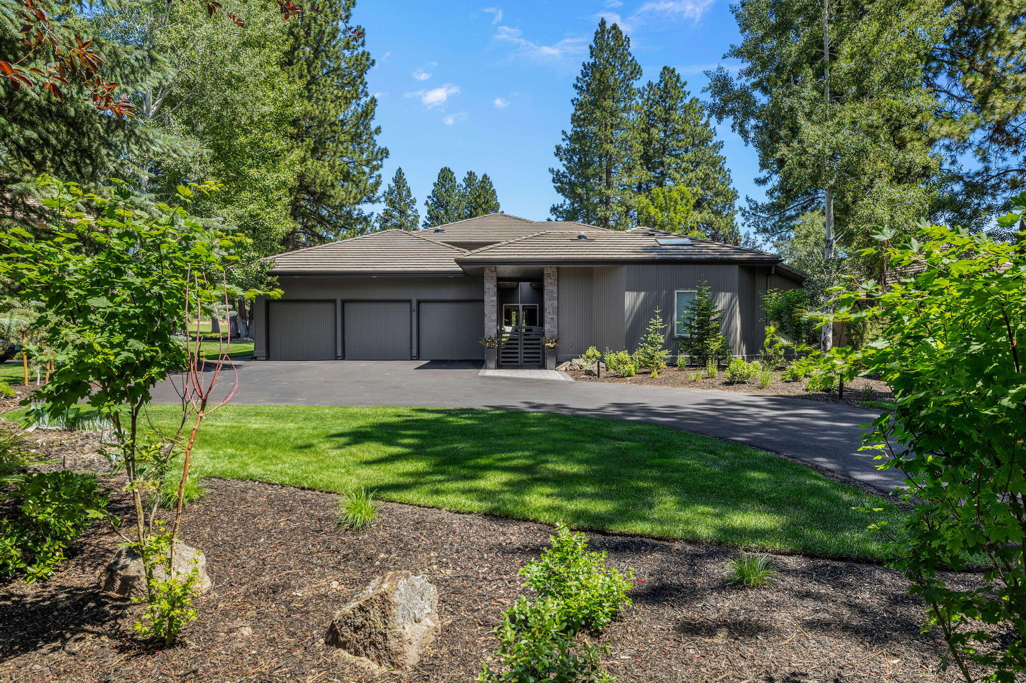 This NW Contemporary home features bright, light filled rooms and expansive main level living with plenty of large spaces inside that flow effortlessly to beautiful new outdoor entertaining spaces. Walls of windows, exposed beams & trusses and stunning views of the 17th fairway, green and lake are featured throughout the home. The private main level primary wing features a fully remodeled bathroom, private patio and  new custom Finnleo dry/steam sauna.  Upstairs offers two additional bedrooms and bathrooms plus a generous family room with built-ins and a second fireplace. The oversized 3 car garage features extensive storage and EV chargers.  As you enter the property, enjoy the newly re-landscaped front yard, new driveway and renovated private courtyard, which is on view from large main level office. Enjoy the quality of this Sun Forest custom home in one of the best locations in Broken Top, w/ convenient access to the club, restaurant, pool, pickleball, park, tennis court & 1st Tee!