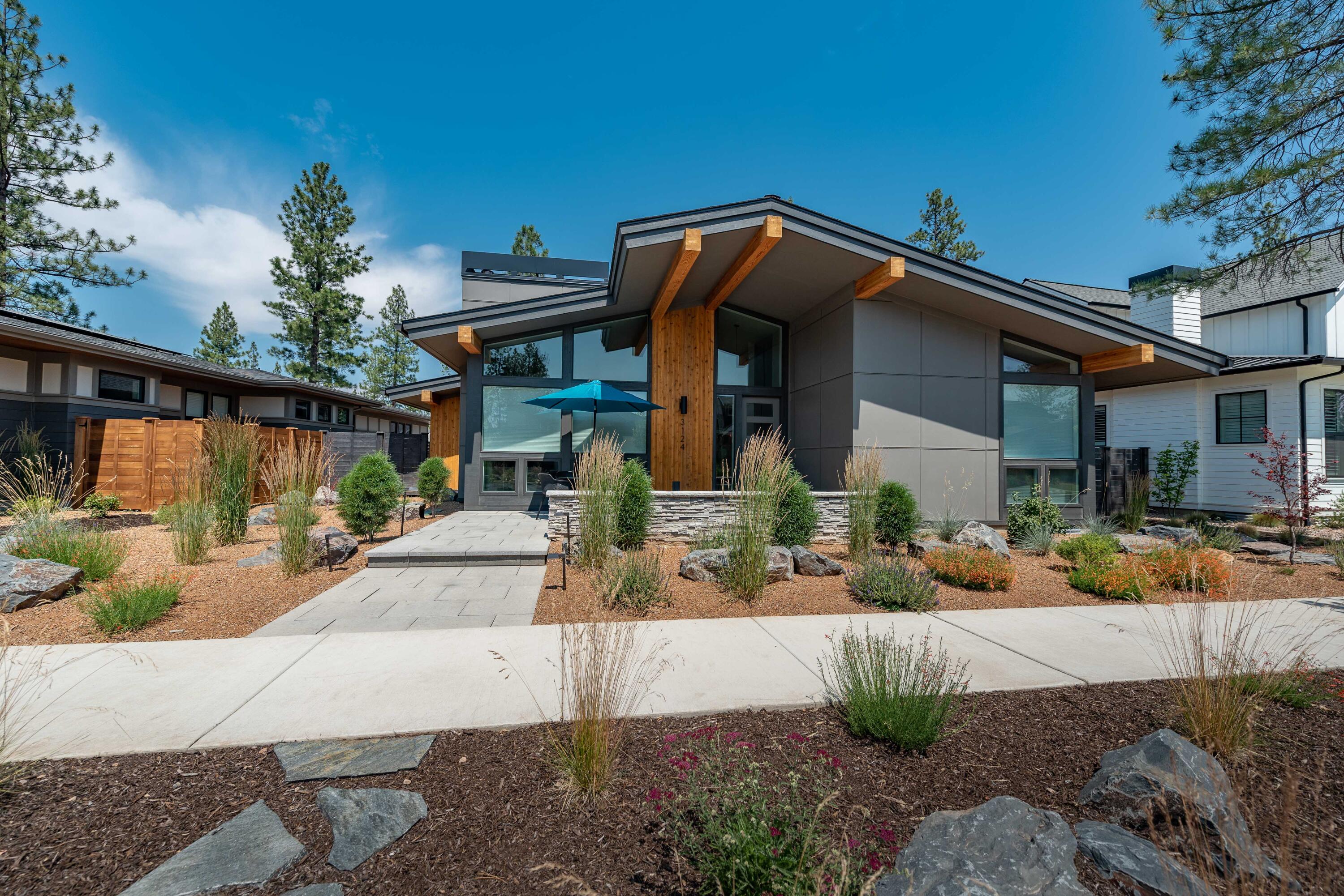 Gorgeous, SINGLE level Mid Century Modern home in the popular Discovery West neighborhood. Walk out your door to all the trails and nearby amenities and live the Bend life to it's fullest. This home, built last year, is just under 1900 SF with three bedrooms and two full baths. The great room with vaulted ceilings, exposed beams, lots of big windows, hardwood floors and a beautiful modern gas fireplace makes for a fun living/entertaining space. The kitchen with an extra large slab island, high end appliances and white cabinetry is the perfect place to prepare your favorite meal. There is a nice sized mud room/laundry room when you enter through the garage. Lots of outdoor living with a southwest facing front porch for your morning coffee and large covered patio off the back of the home for those warm, summer afternoons. Low maintenance landscaping with no grass to mow. The backyard is fully fenced. The two car garage is off the alley behind the home. Come see it today!