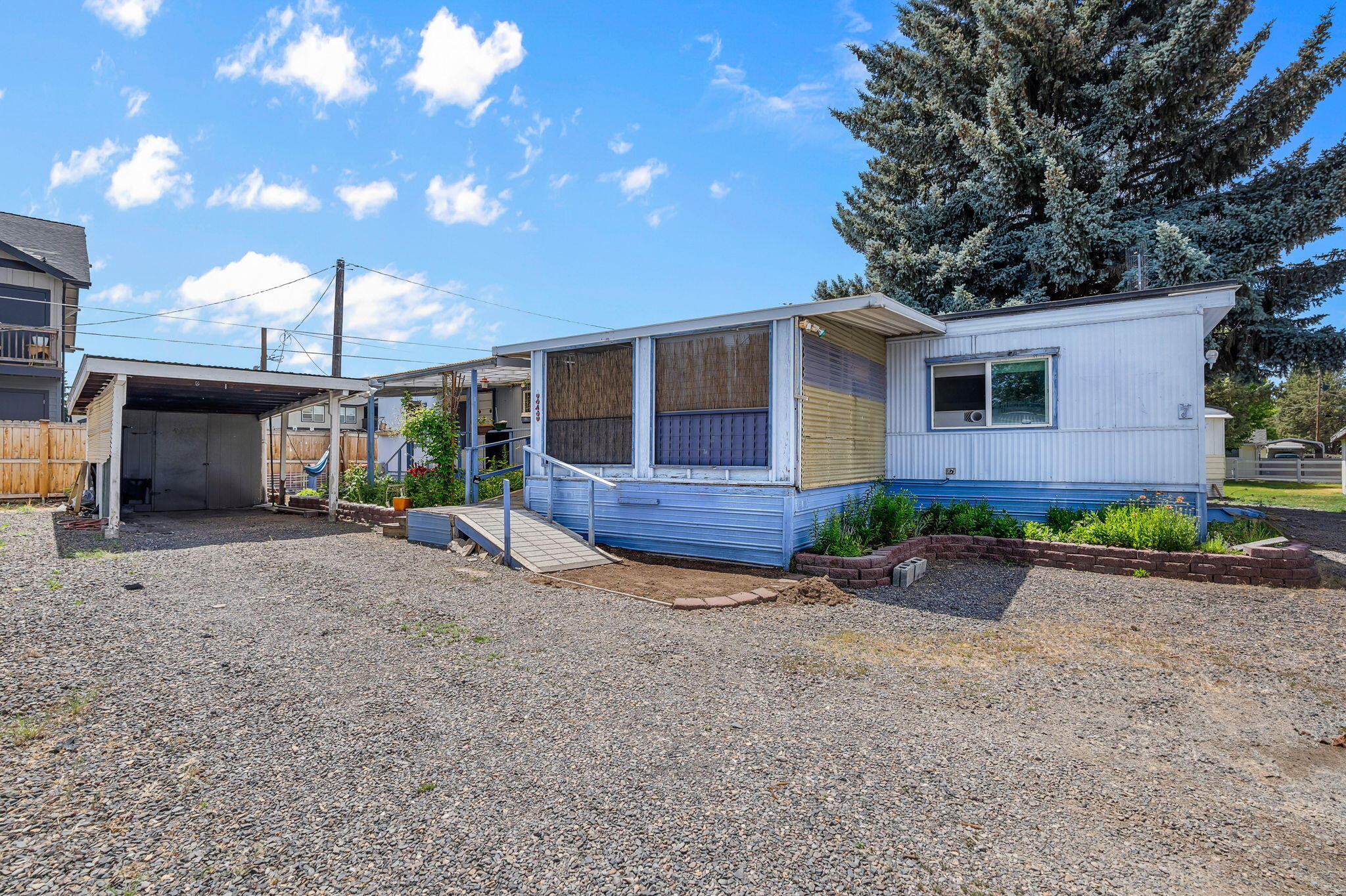 Located in a 55+ well maintained community close to downtown Redmond shopping, restaurants, healthcare & recreation. Well sized living area boasts laminate flooring, an abundance of natural light & windows w/separate dining & kitchen areas. Kitchen has plenty of cabinetry storage & counter space for prep, with all appliances included. Small dining area located adjacent to the kitchen. Spacious primary & secondary bedroom with access to full bath featuring step in shower. Washer/Dryer area w/shelving. Outside you'll find a well sized screened in porch, garden areas, sheds, accessible ramp access to home, & a covered carport parking space. Don't miss this one, it won't last! Current land lease of $618/month