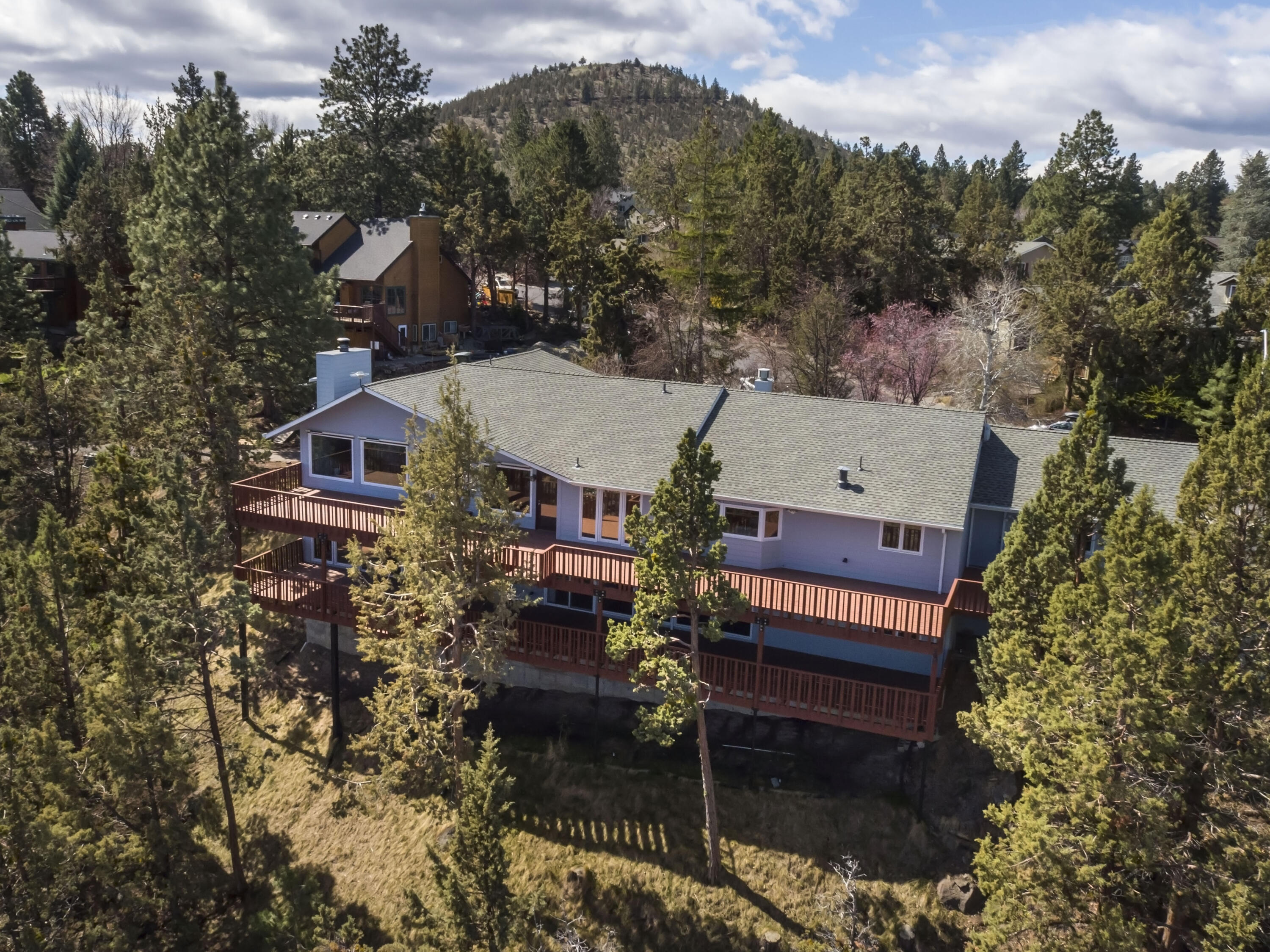 Soaking up the Central Oregon sunshine has never been easier. With two entertainment decks that see forever and large picture windows, sunshine is abundant in this beautifully remodeled home perched high in the tree tops. Sweeping eastern and southern panoramic views of Bend. Located in Midtown paradise with privacy, beauty and elbow room on a .64 acre lot. Main level living featuring a beautifully remodeled chef's kitchen with custom tile, bamboo flooring, wood burning fireplace and primary bedroom with spa-like accents. Additional two bedrooms with Jack & Jill bathroom. At the end of the day, relax and unwind in your very own private spa complete with a dry sauna and Whirlpool hot tub. Less than a mile from St. Charles Hospital and medical center, centrally located near schools, restaurants and shopping. You will enjoy the quiet, tree-lined, established neighborhood just 5 minutes from downtown Bend. This is Bend living at its best!