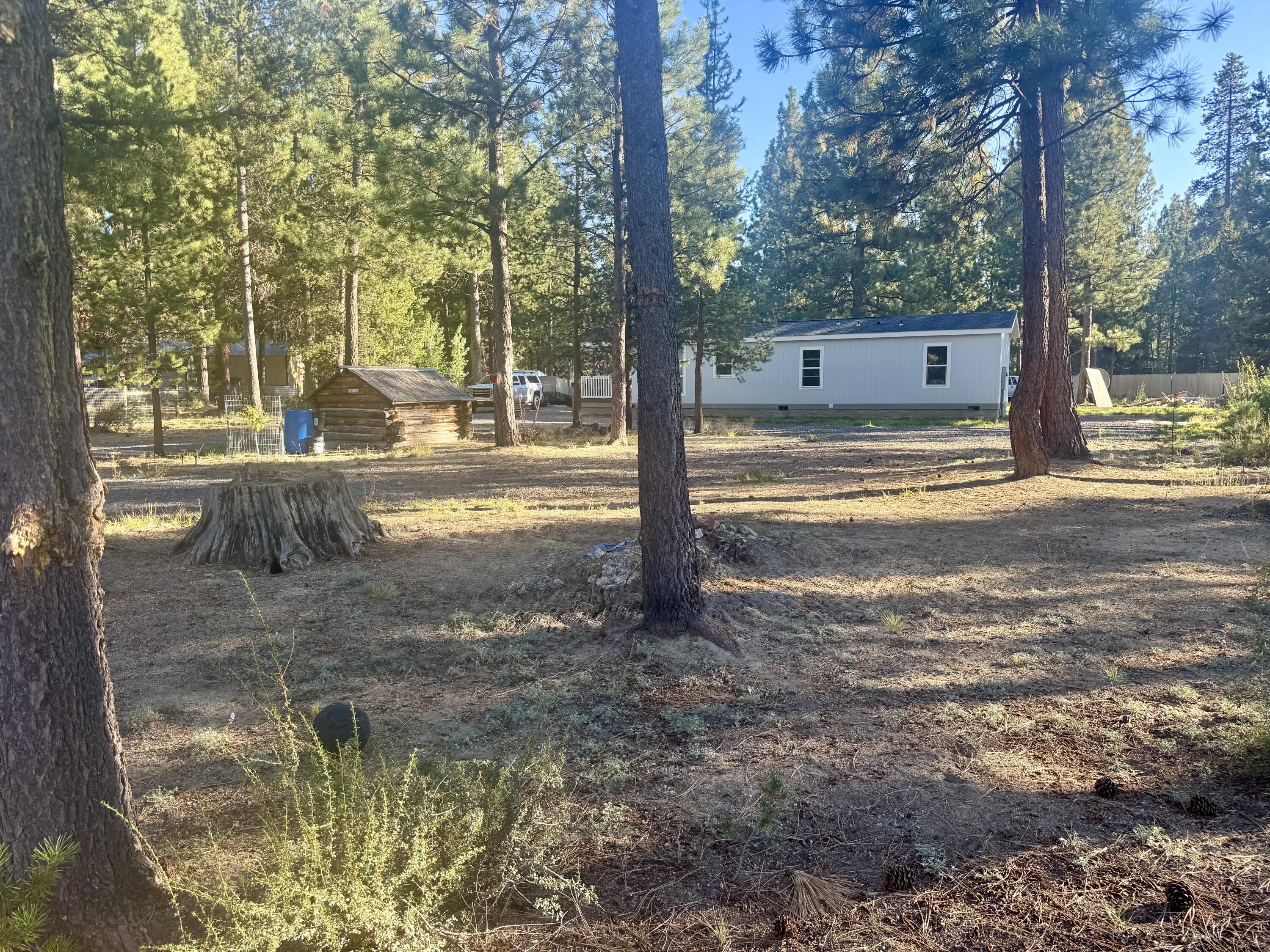 Welcome to your own private retreat on a fenced 1.2-acre lot, featuring a 2024 Dream Series Manufactured Home. Enjoy 624 sq ft of comfortable living space and a charming 104 sq ft covered front Trex deck—perfect for morning coffee or evening relaxation. With 2 bedrooms and 1 bath, this home offers laminate flooring,  carpeting in the bedrooms, and space for a stackable washer and dryer. Ceiling fans and a woodstove create a warm, inviting atmosphere.  Storage buildings and a 40-foot Konex container, ensuring you have plenty of room for all your belongings.