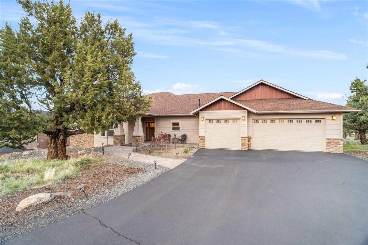Gorgeous single-level custom home with a SIX CAR garage and beautiful views of Smith Rock in Eagle Crest Resort! This open-concept plan is ideal for hosting family and friends with the large open great room, kitchen with gorgeous slab granite countertops, expansive breakfast bar, gas range, double ovens, walk-in pantry, and spacious dining room. Take the party to the deck and enjoy the beautiful views and incredible Central Oregon starlit sky. Primary suite with slab granite counters, walk-in closet, dual sink vanity, jacuzzi tub, and tiled walk-in shower. Two guest rooms with walk-in closets, full bath, and laundry room with utility sink and built-in cabinets for storage. This home has abundant storage options including a large double-door closet with shelves, walk-in pantry in the kitchen, coat closet in the entryway, walk-in closets in all bedrooms, storage cabinets in the laundry room, and a six car garage! Enjoy all Eagle Crest amenities.