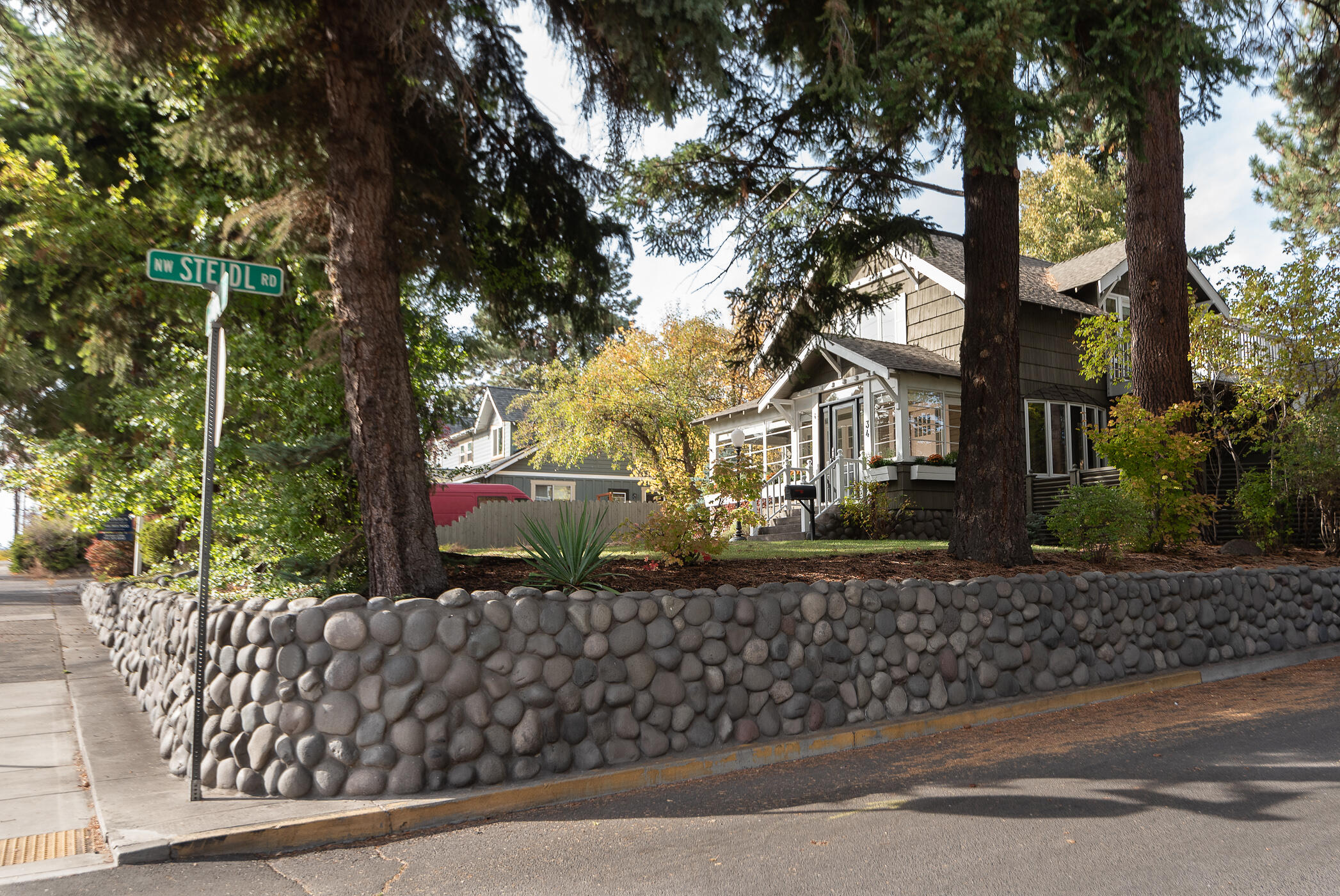 This iconic Bend Craftsman home sits on a elevated large corner RM zoned lot in the coveted River Terrace neighborhood. Just ONE block from Wall Street, Pioneer Park and Deschutes River Trail System. This 4 bedroom, 3 Bath home has new wool carpet, joyful interior paint, new light fixtures & improved landscaping/patios. The kitchen and butler pantry flow elegantly into the dining and living room. The spacious basement is a bonus for extra flex space/storage. Enjoy peaceful river views from your living room, Southside sunroom or from the upstairs primary suite balcony. A fully fenced yard with mature trees provides a haven for all your enjoyment. A few blocks to Bend's premier downtown eateries, boutique shopping and trails. The detached 3 car garage and additional onsite parking provide easy living and RV parking. Don't miss this rare opportunity!