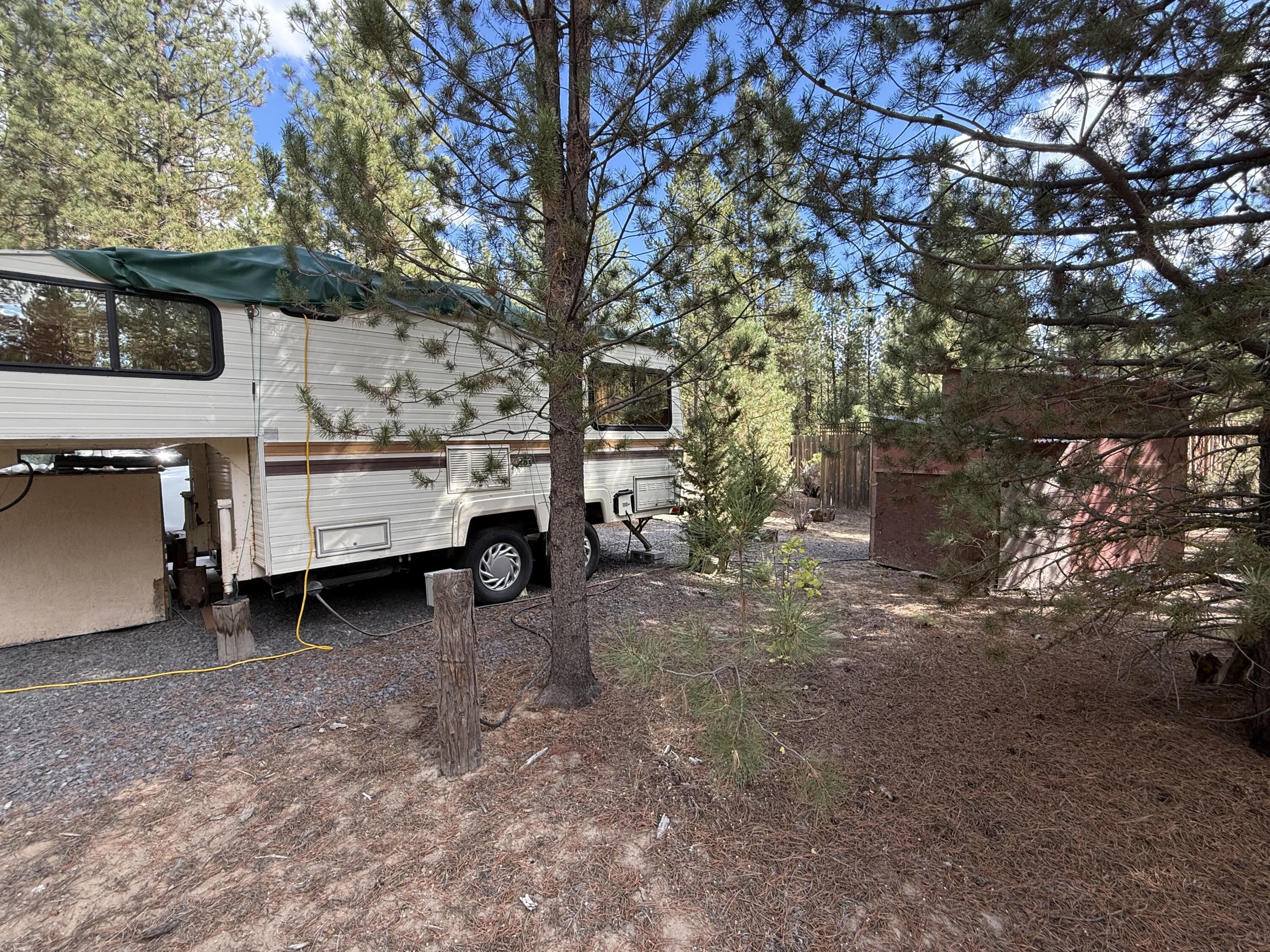 Discover this partially improved lot in the Sprague River Pines community, featuring an existing well and electric service already in place. Whether you're looking for a peaceful camping retreat or planning
for a future home site, this property offers great potential. The lot includes a 5th wheel, well house, shed, and a fenced privacy area (approximately 20x30) with an enclosed cedar fence. Enjoy community river access exclusively for Sprague River Pines members, and benefit from a privately maintained road system within the neighborhood. The seller previously received approval for septic installation and home construction; while that approval has since expired, the documentation
is available through the listing agent. Buyers are advised to conduct their own due diligence regarding permits, plans, and intended use. Existing structures were on the lot prior to current owner's purchase.