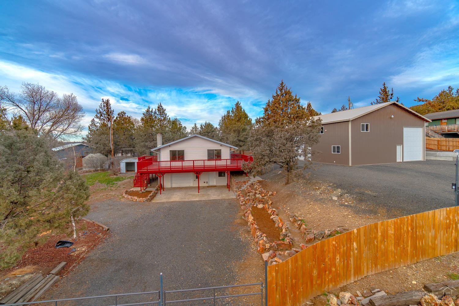 Cozy up next to the fire & enjoy incredible views of the Valley & Ochocos beyond. Situated on 3 lots, move in ready home with a fantastic new 40x48 shop with 12 & 14 ft rollup doors! Home features a wrap around deck, French door entry into an open living space complete w/wood burning fireplace. Real hardwood floors in the main living area, durable laminate in the kitchen. SS appliances including the Refrigerator, dishwasher & range. 2 bedrooms on the main level + huge laundry room & pantry. Daylight basement w/additional bedroom & bath & finished garage that's currently used as a bonus room/studio. Bath has Quartz counters & modern lighted mirrors & sleek new fixtures. Outside there is plenty of space to garden, low maintenance landscape & all is fully fenced & gated! Bring your toys, RV's & hobbies - there's even a storage room & loft already in the shop. Already wired for 220 power w/full slab floor. Community amenities include a pool, stables, fishing pond, shooting range & more!