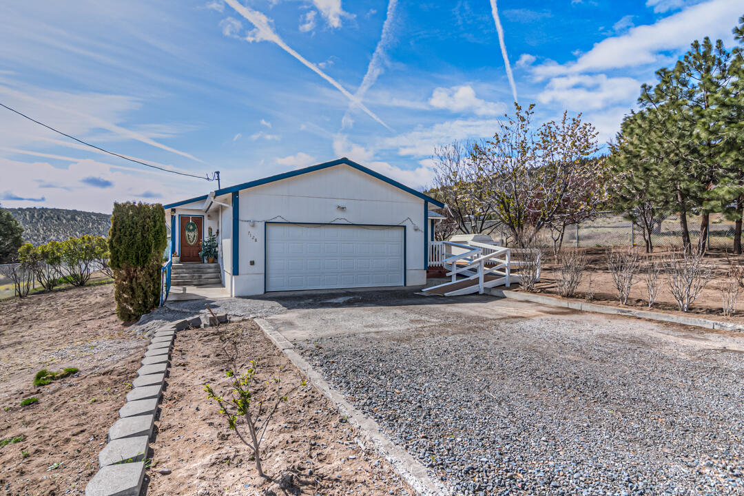 Large stick built home sitting on 1.85 acres SE of Prineville! Great views and room to park your toys, horses, RV or build a shop. This home has 4 bedrooms two of which are primary suites, 3 full baths and is 1968 sq ft. Permitted addition was done in 2007. Offering an open floor plan with vaulted ceilings, new vinyl flooring in bathrooms, an island and a pantry in the kitchen as well as upgrades this year including new white appliances, tile backsplash, laminate countertops and laminate flooring throughout. Handicap accessibility. New roof is 5 years old, garage is oversized. House and yard are fenced in, property goes beyond on both sides. Clean and ready to go. Only 10 minutes from Prineville, and 12 miles away from Prineville Reservoir. Front half of driveway is now concrete paved. Seller offering $5,000 credit to buyer to buy down interest rate, use towards closing costs, or use towards new flooring in carpeted bedrooms if they choose.