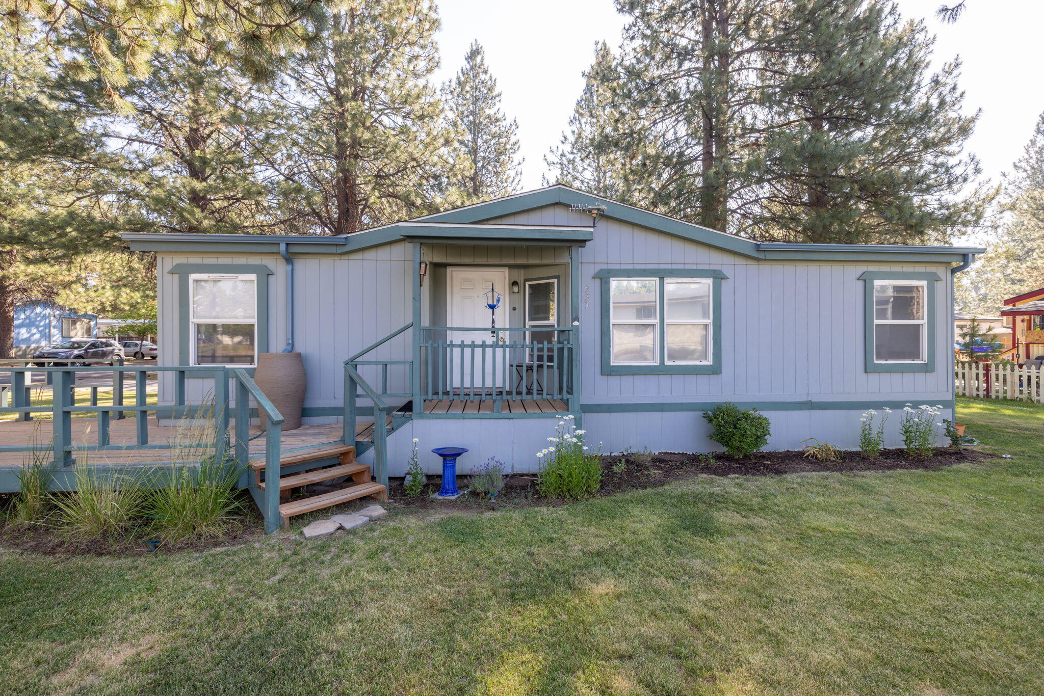 Enjoy the beauty of a corner lot from the comfort of your home or the shaded front deck. Tucked away in The Pines Mobil Home Park you find the perfect place to call home. This cozy 3 bedroom is ready for you to make it your own. It even has an attached covered driveway. Get it while you can!