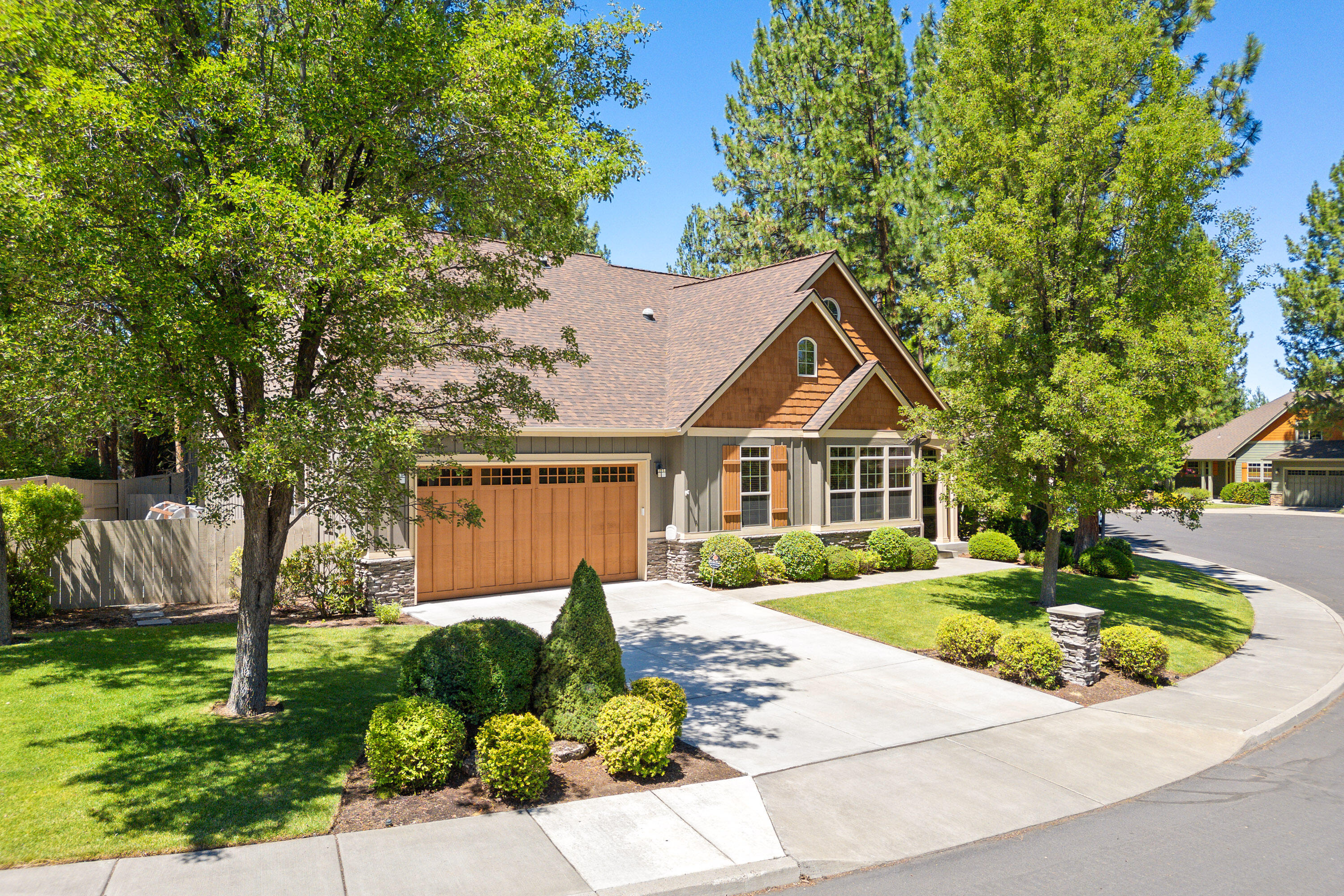 Situated among towering pines on a private quarter-acre lot in RiverRim, this beautifully maintained single-level Hendrickson-built home exudes incredible curb appeal and blends elegance with everyday functionality. An open great room features vaulted ceilings with exposed beams, a cozy fireplace, and large windows that fill the home with natural light. The kitchen includes stainless appliances, a gas range, and solar tubes, flowing into a dining area with built-in cabinetry. The expansive primary suite is a relaxing retreat with dual vanity, soaking tub, and walk-in closet. Wood trim, fully cased windows, and 8-foot wood doors add warmth throughout. The landscaped backyard is fully fenced with spacious side yards, a covered patio and large deck with a pergola. Additional highlights include a new roof and air conditioner (2023), new driveway, plus a 3-car garage with excellent storage. Lightly used as a second home and ideally located near parks, trails, and all that SW Bend offers.